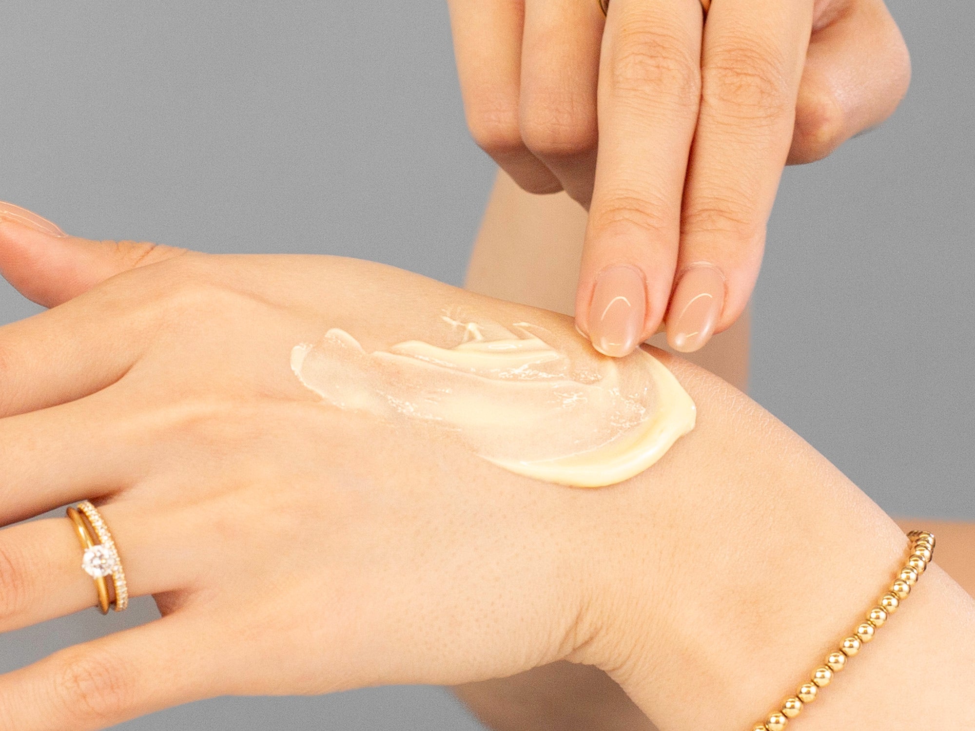 Laziza from LAZ Skincare applying Alastin A-Luminate Brightening Serum to her hand