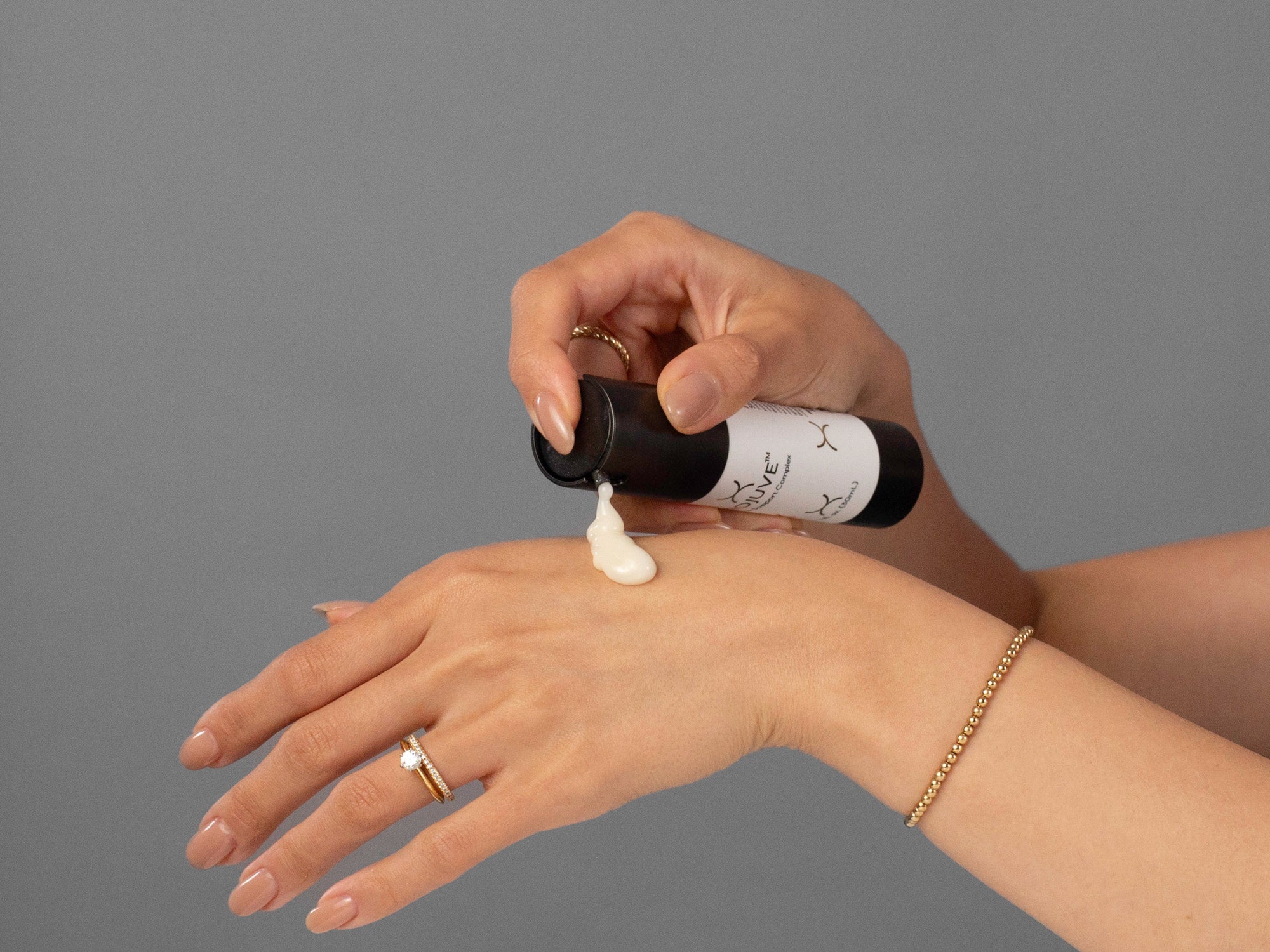 Closeup of Laziza from LAZ Skincare applying BioJuve Biome Support Complex to her hand