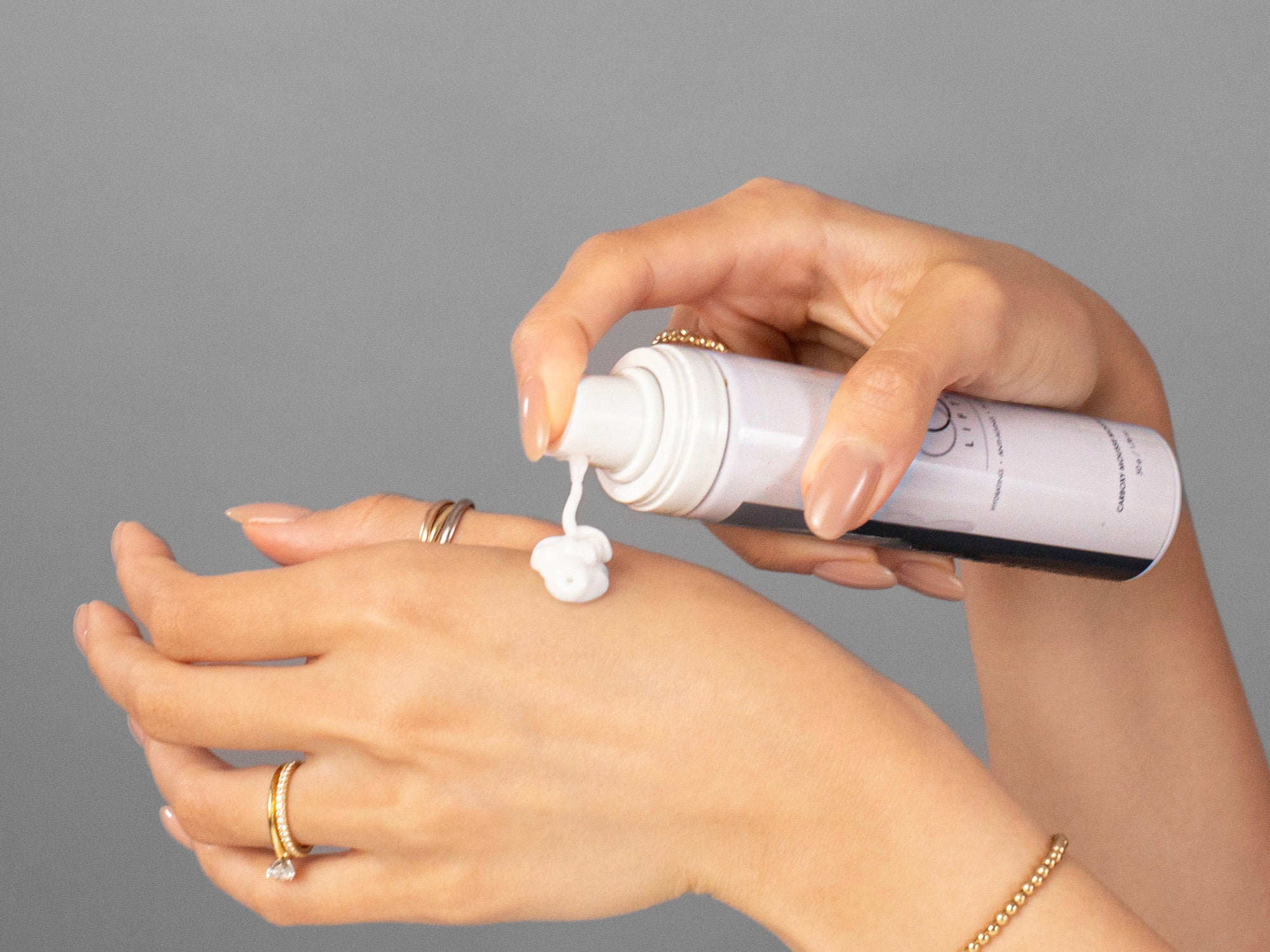 Closeup of Laziza from LAZ Skincare applying CO2Lift Carboxy Mousse Moisturizer to her hand