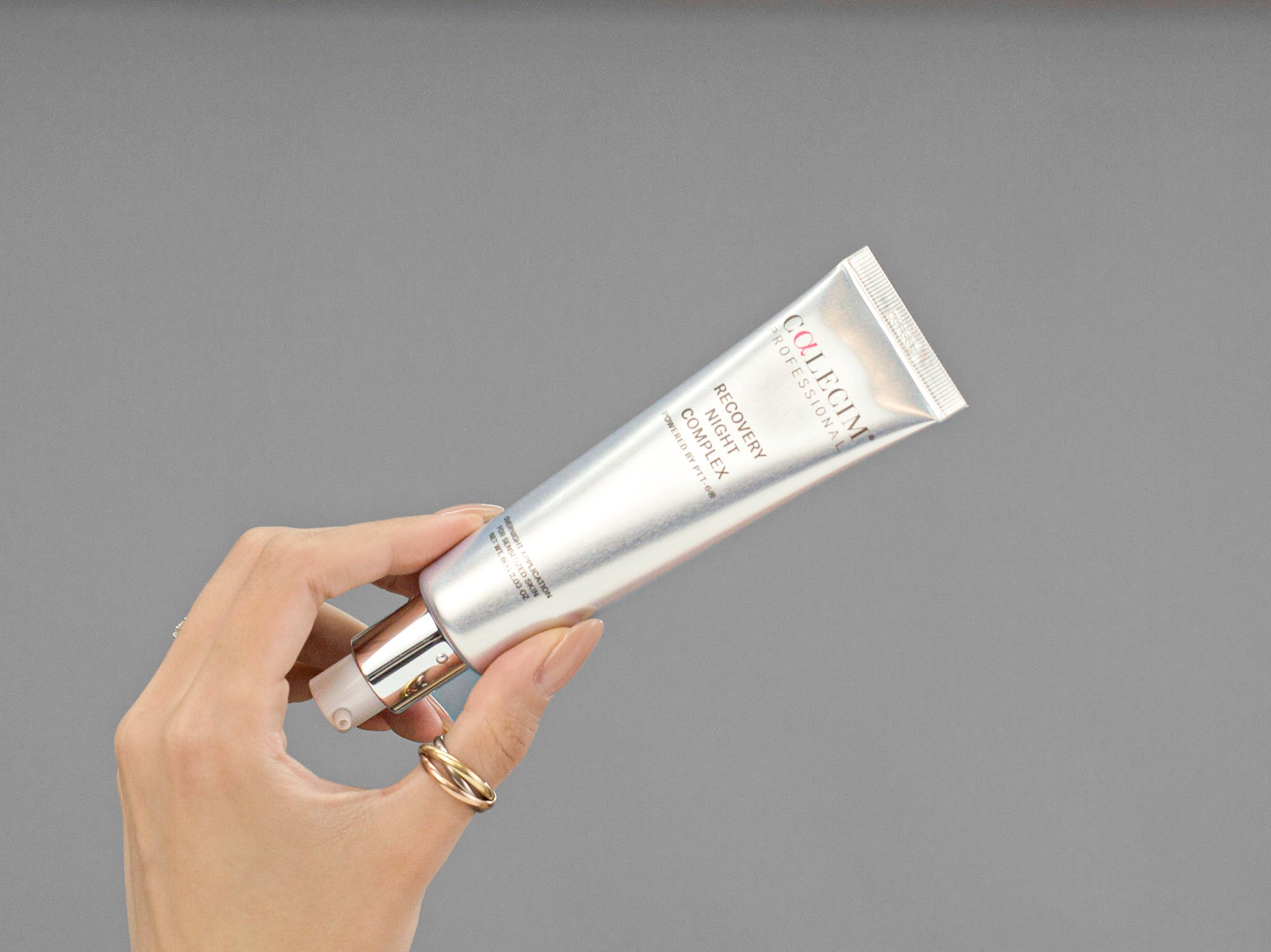 Closeup of Laziza from LAZ Skincare holding a tube of Calecim Recovery Night Complex