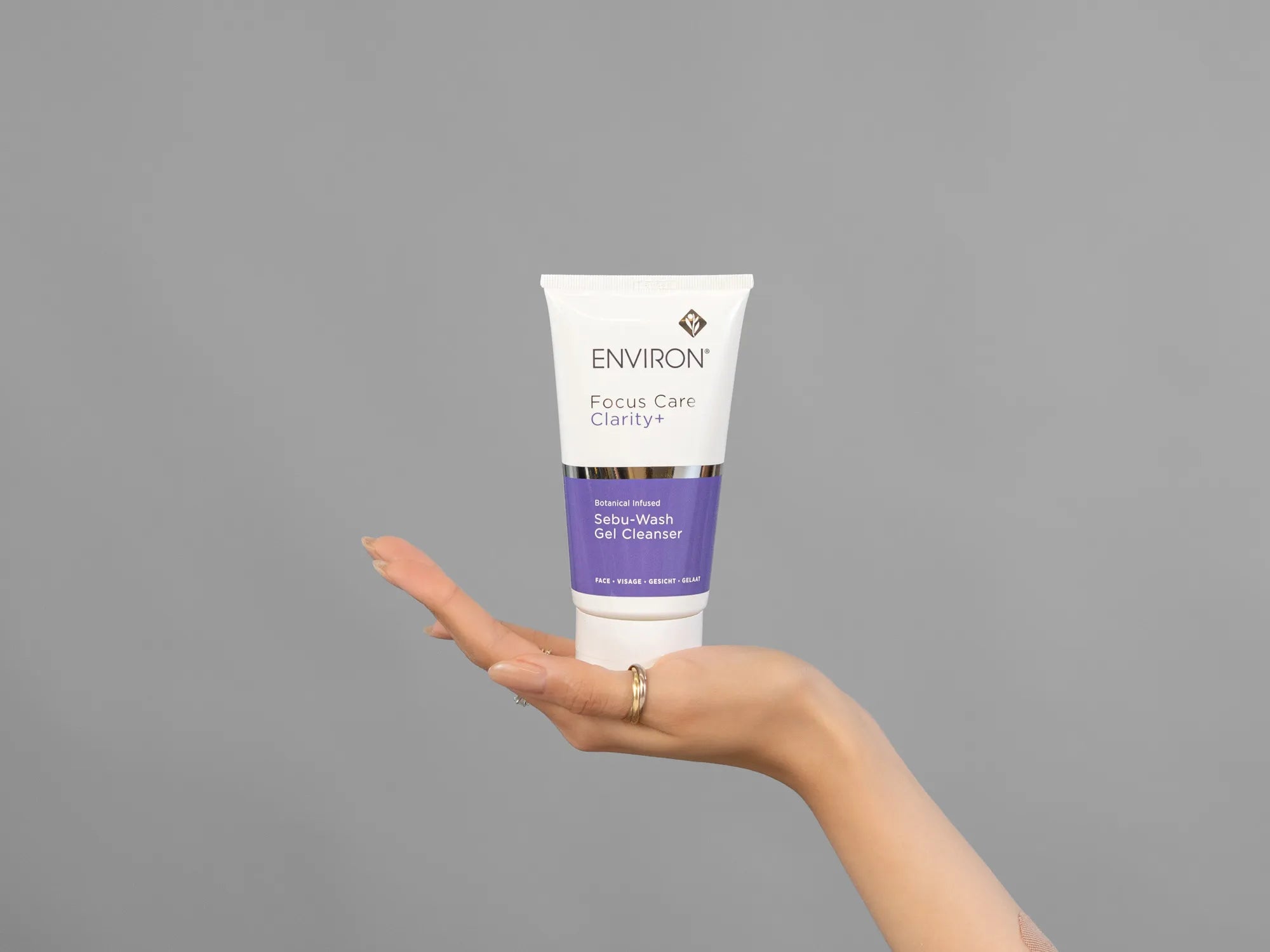 Closeup of Laziza from LAZ Skincare holding up a bottle of Environ Sebu-Wash Gel Cleanser