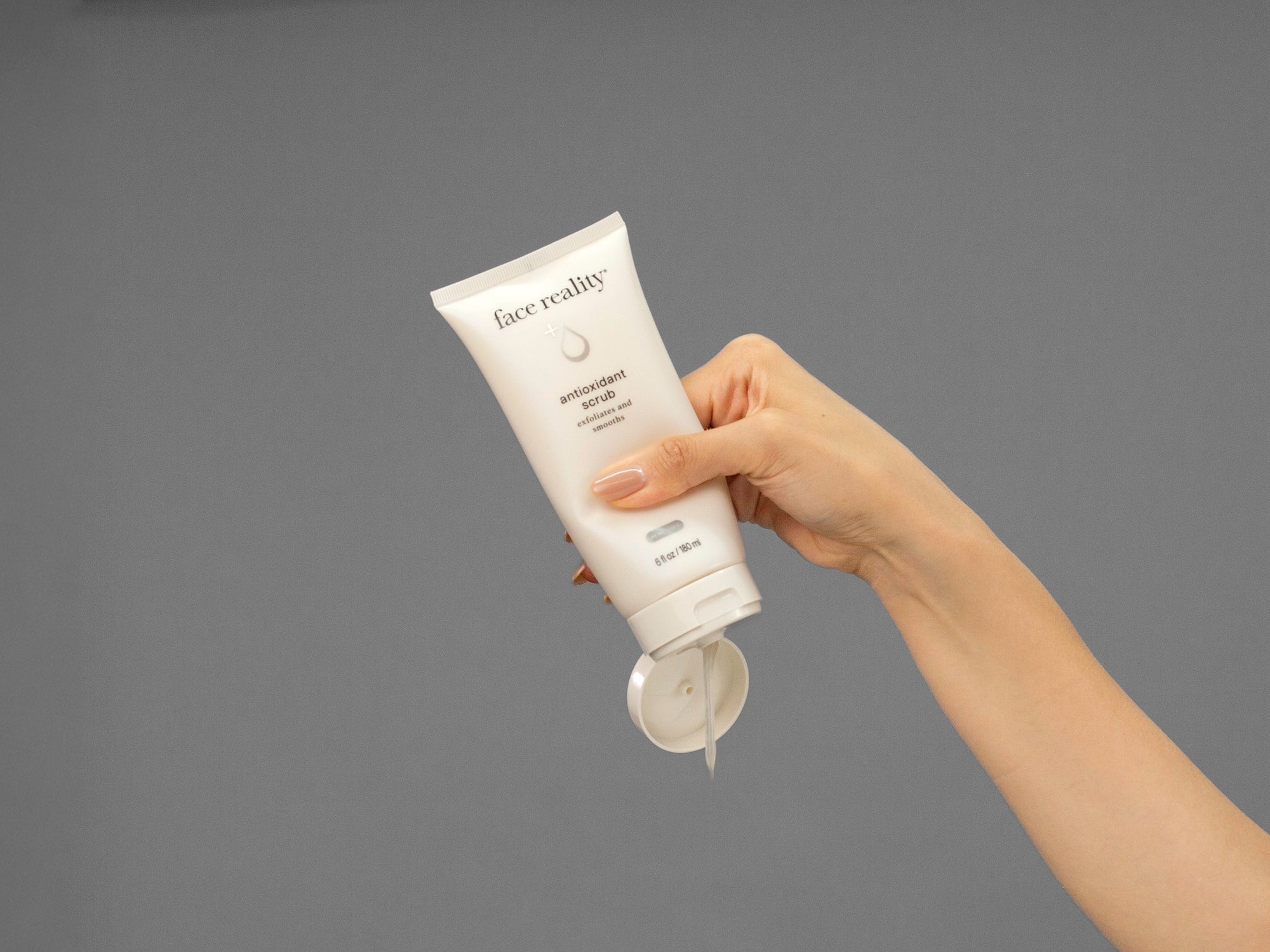 Closeup of Laziza from LAZ Skincare squeezing a tube of Face Reality Antioxidant Scrub