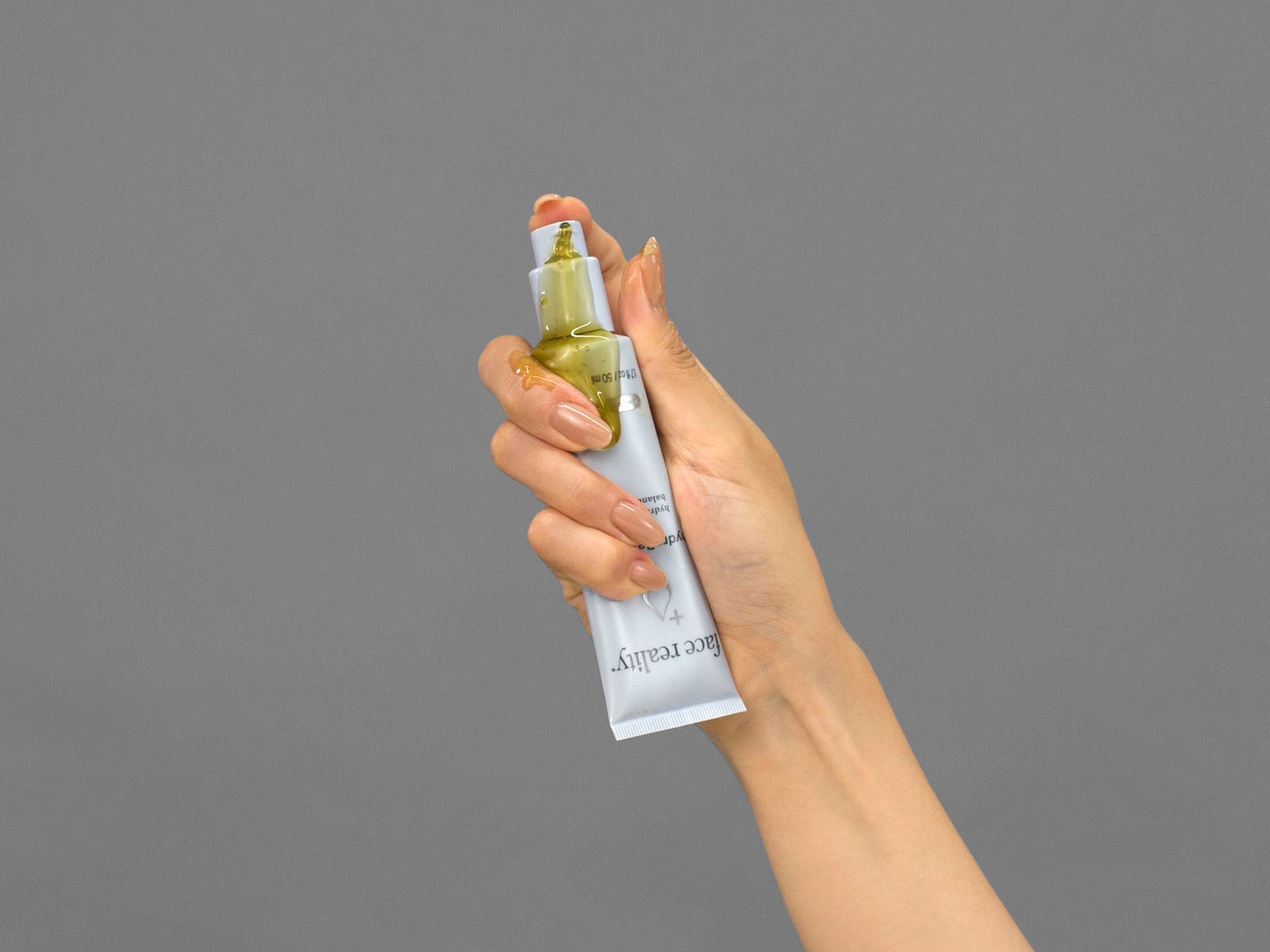 Closeup of Laziza from LAZ Skincare demonstrating the pump on a tube of Face Reality HydraBalance Gel