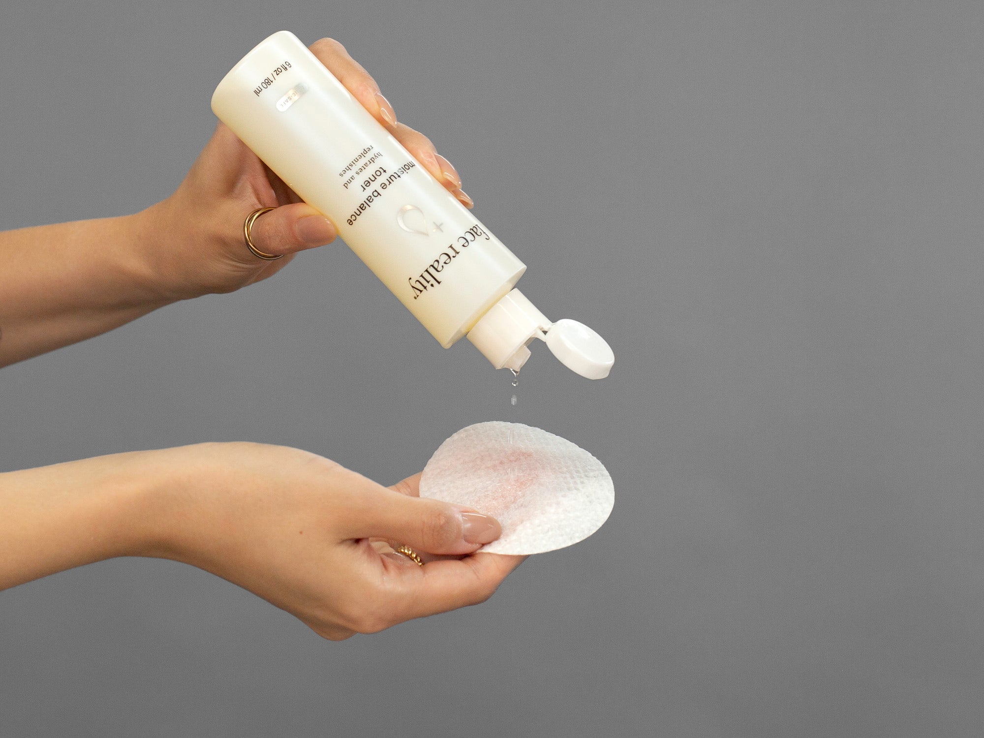 Closeup of Laziza from LAZ Skincare applying Face Reality Moisture Balance Toner to a cotton pad