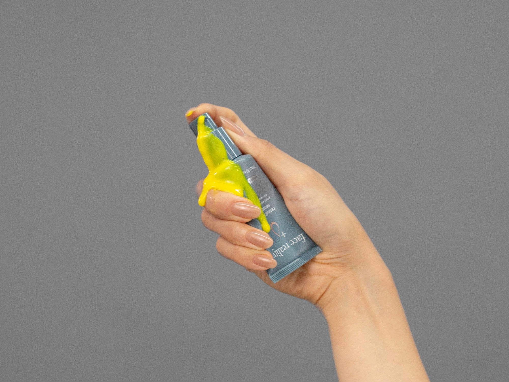 Closeup of Laziza from LAZ Skincare holding a tube of Face Reality Retinal B3 Serum in her hand