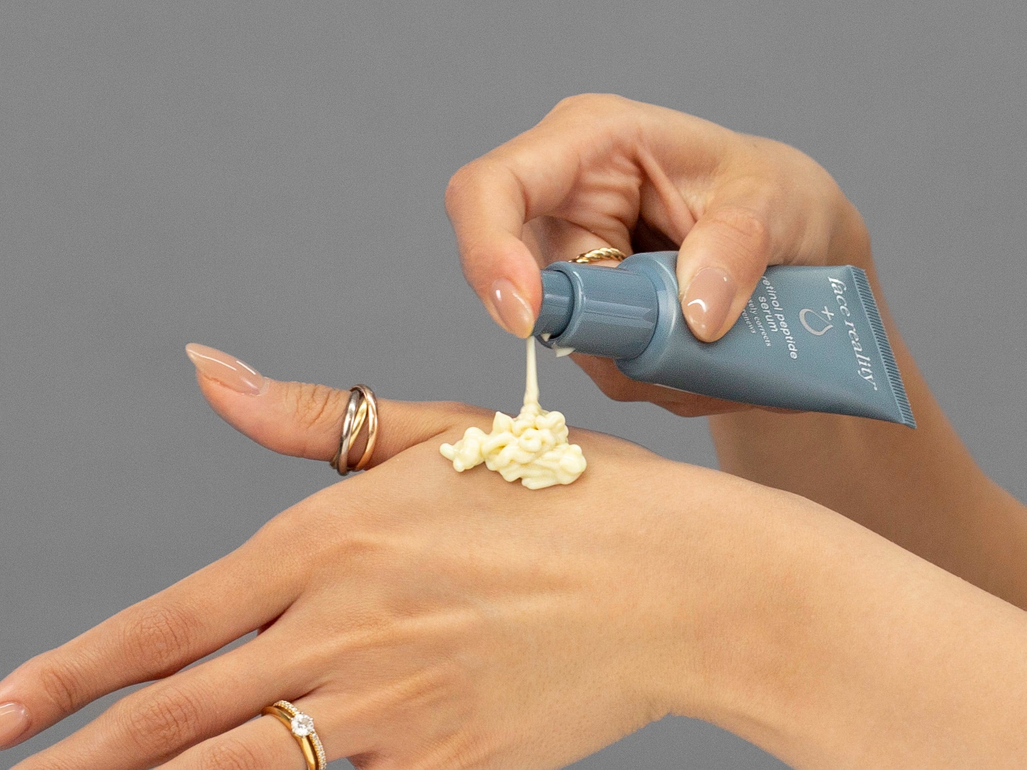 Closeup of Laziza from LAZ Skincare applying Face Reality Retinol Peptide Serum to her hand