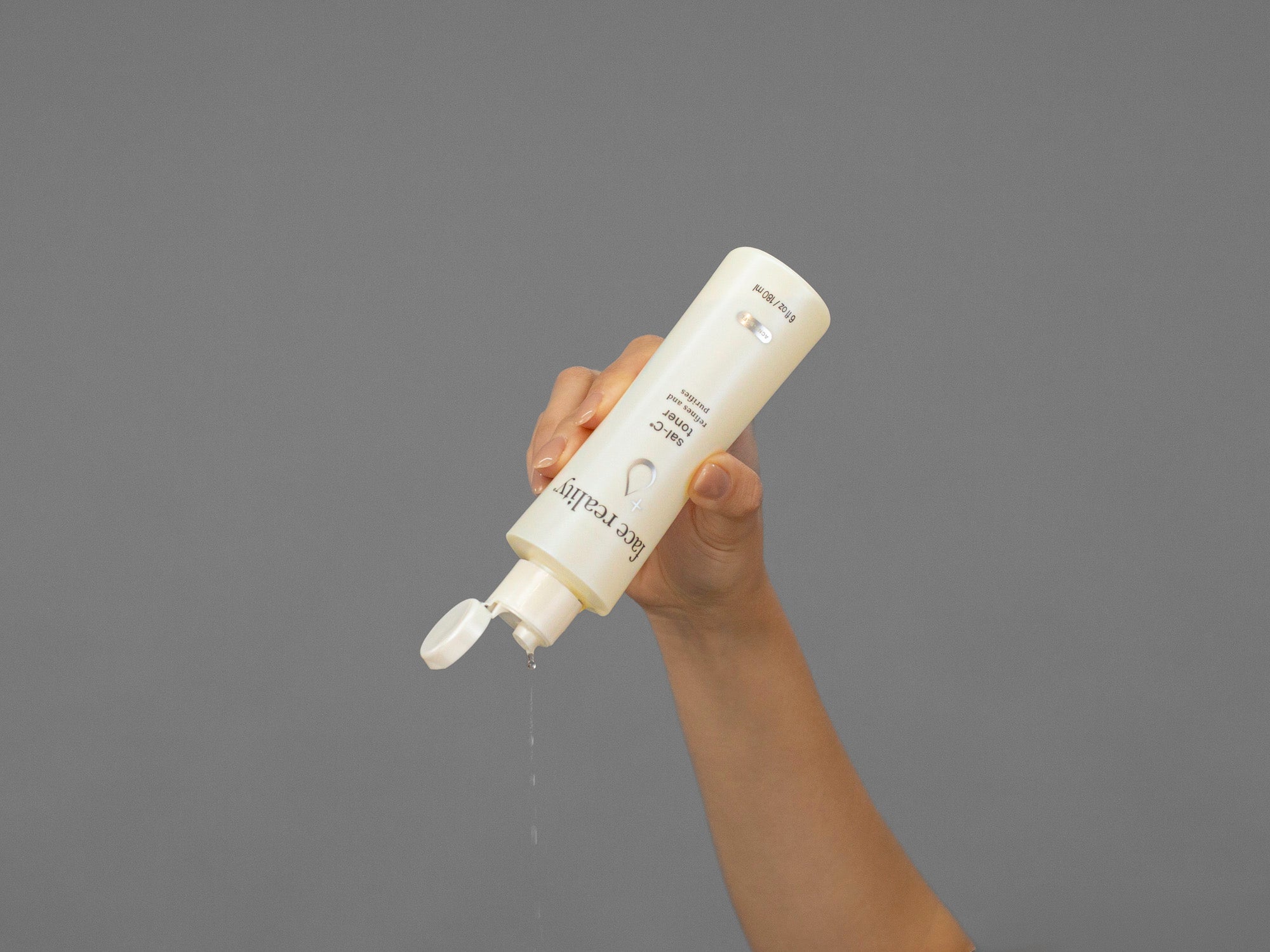 Closeup of Laziza from LAZ Skincare squeezing a bottle of Face Reality Sal-C Toner