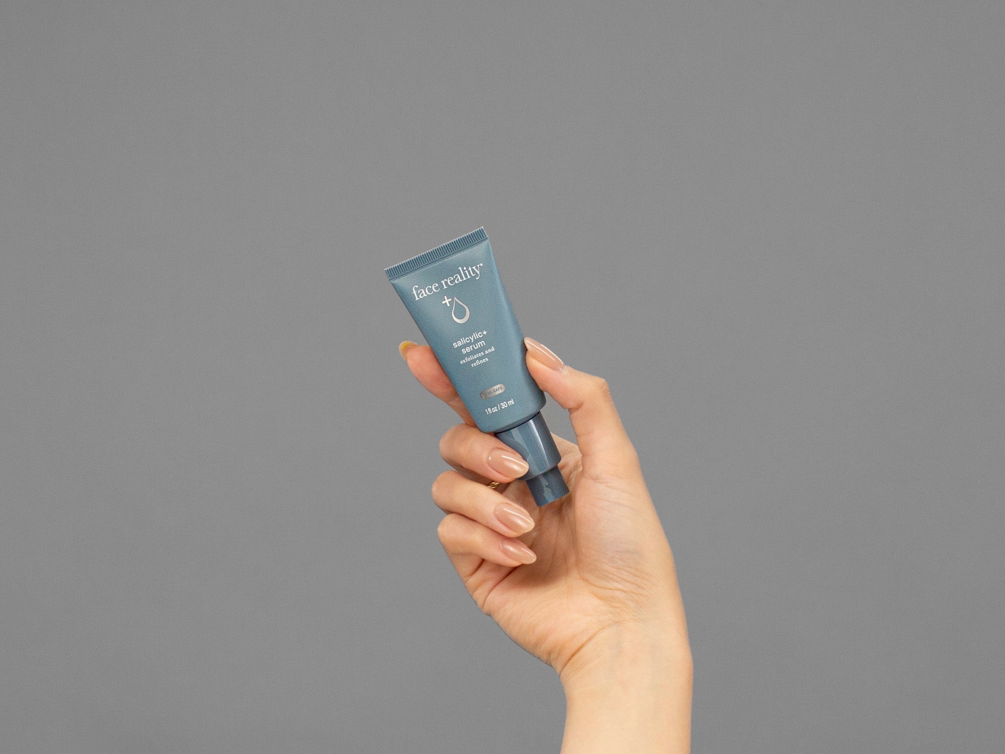 Closeup of Laziza from LAZ Skincare holding up a bottle of Face Reality Salicylic Serum