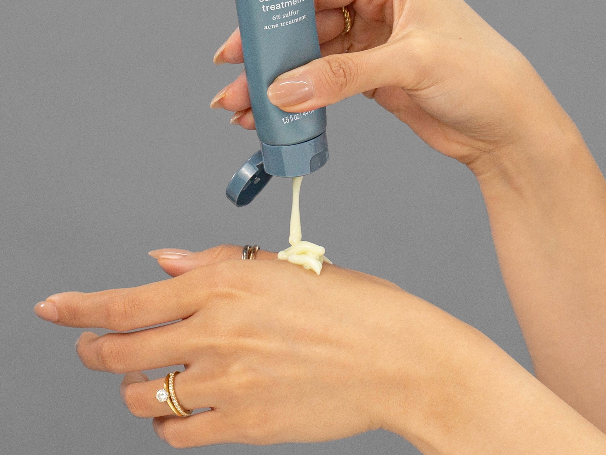 Closeup of Laziza from LAZ Skincare applying Face Reality Sulphur Spot Treatment to her hand