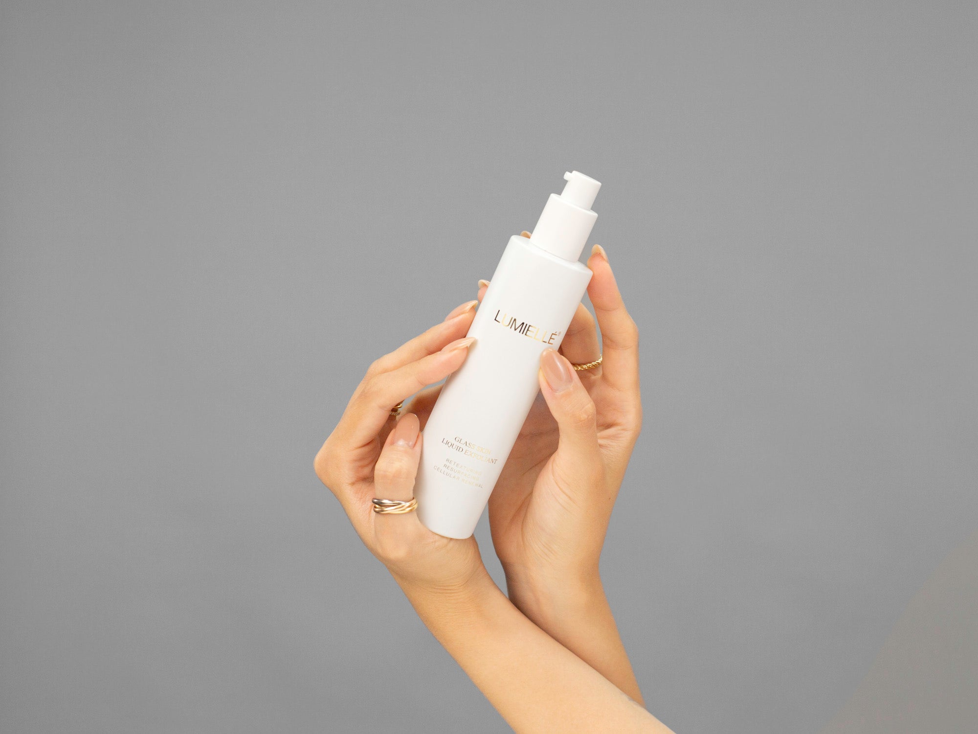 Closeup of Laziza from LAZ Skincare holding a bottle of Lumiellé Glass Skin Liquid Exfoliant in her hands