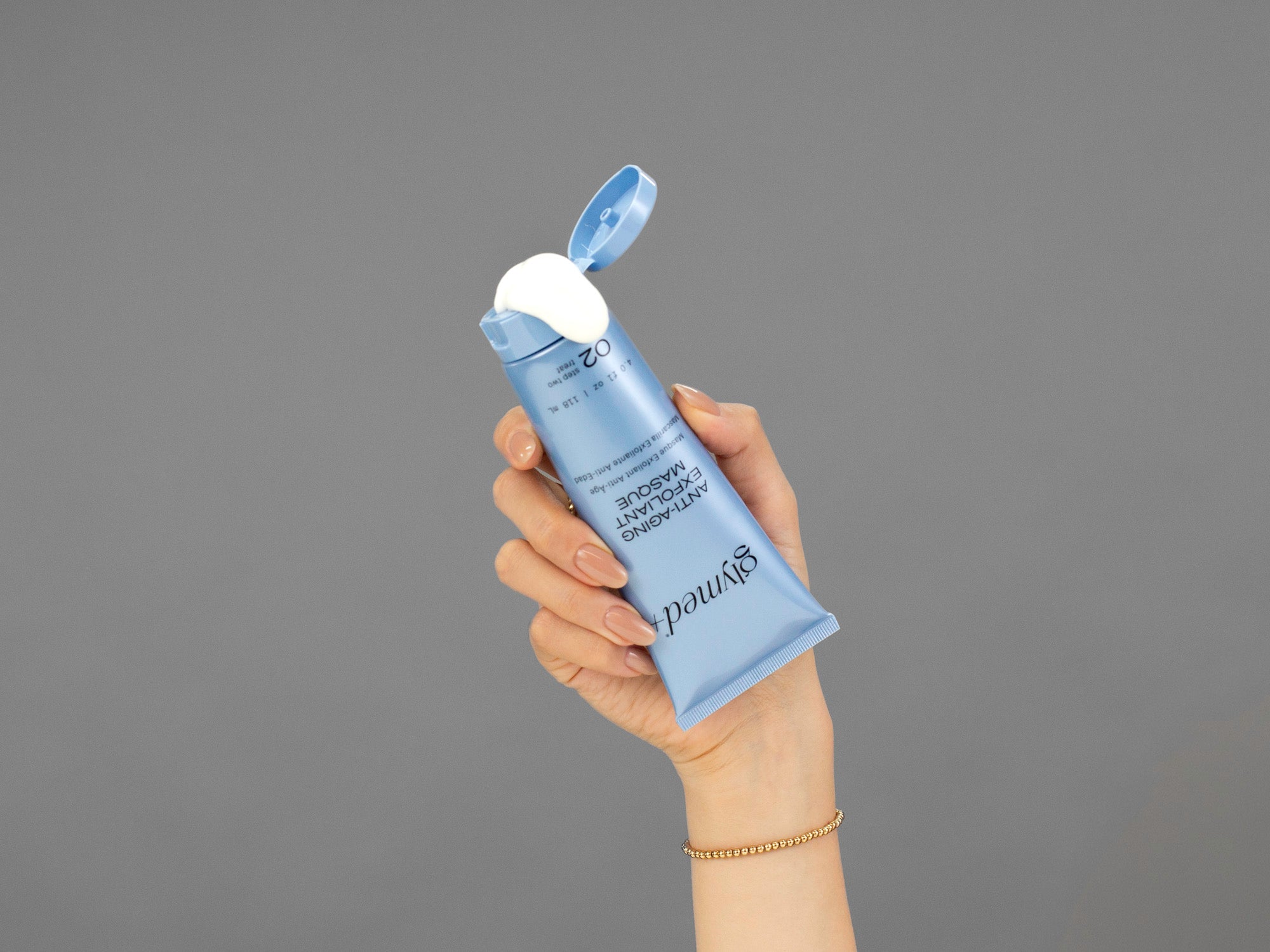 Closeup of Laziza from LAZ Skincare squeezing a tube of GlyMed Anti-Aging Exfoliant Masque