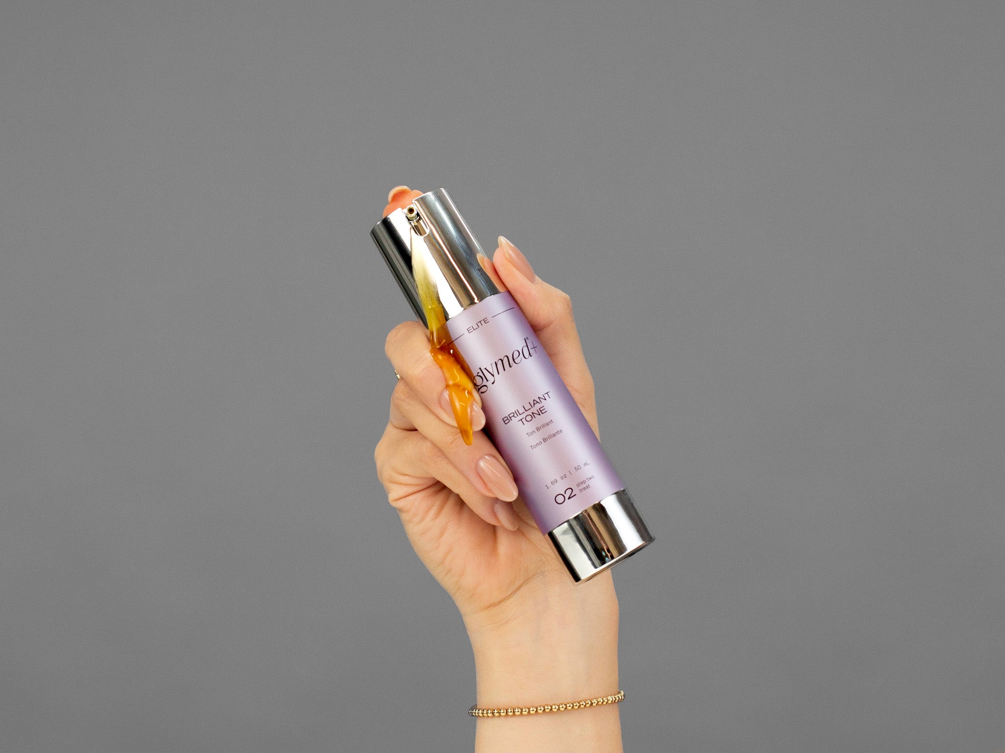 Closeup of Laziza from LAZ Skincare holding a bottle of GlyMed Brilliant Tone in her hand