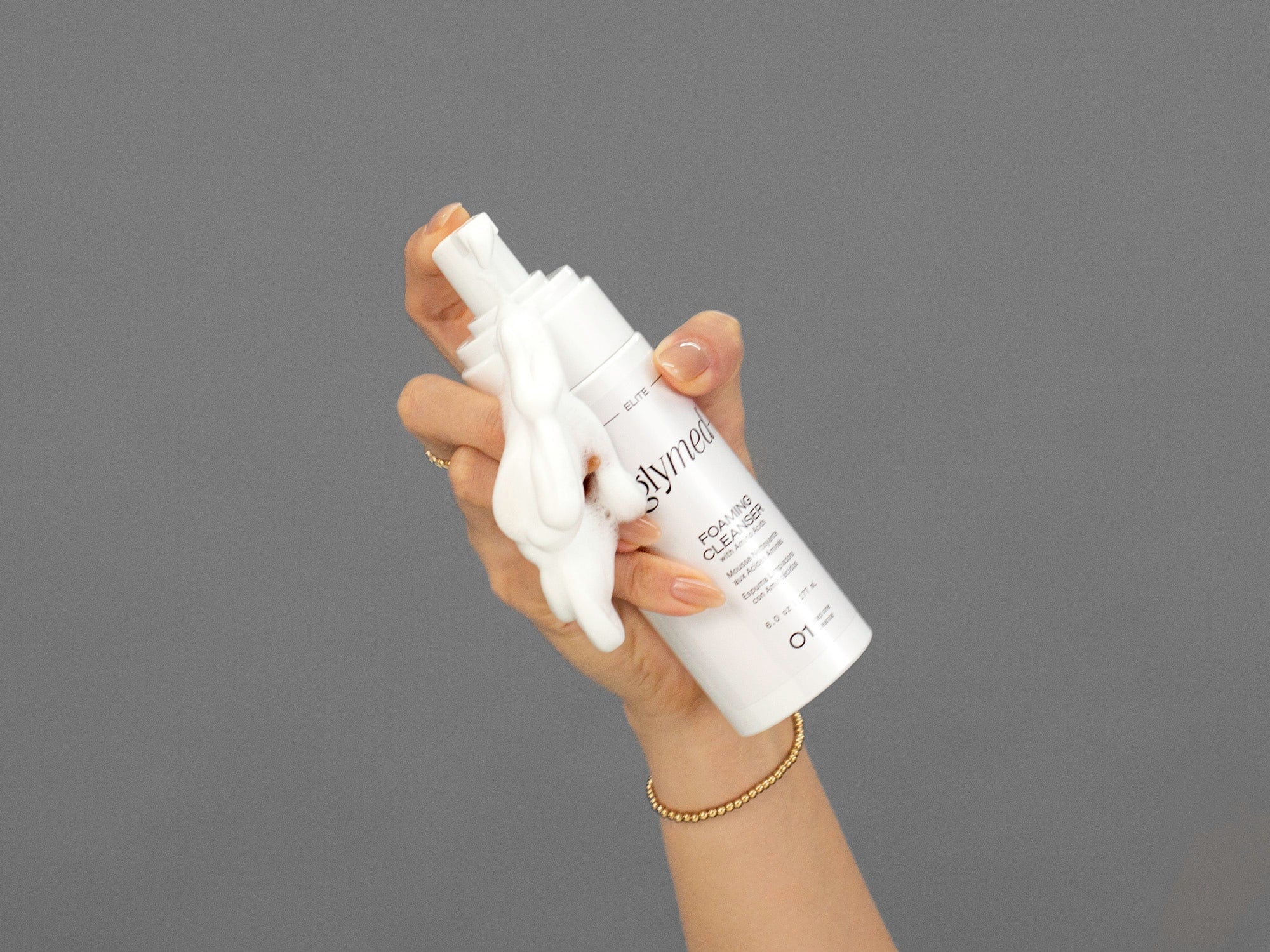 Closeup of Laziza from LAZ Skincare holding a bottle of GlyMed Foaming Cleanser in her hand