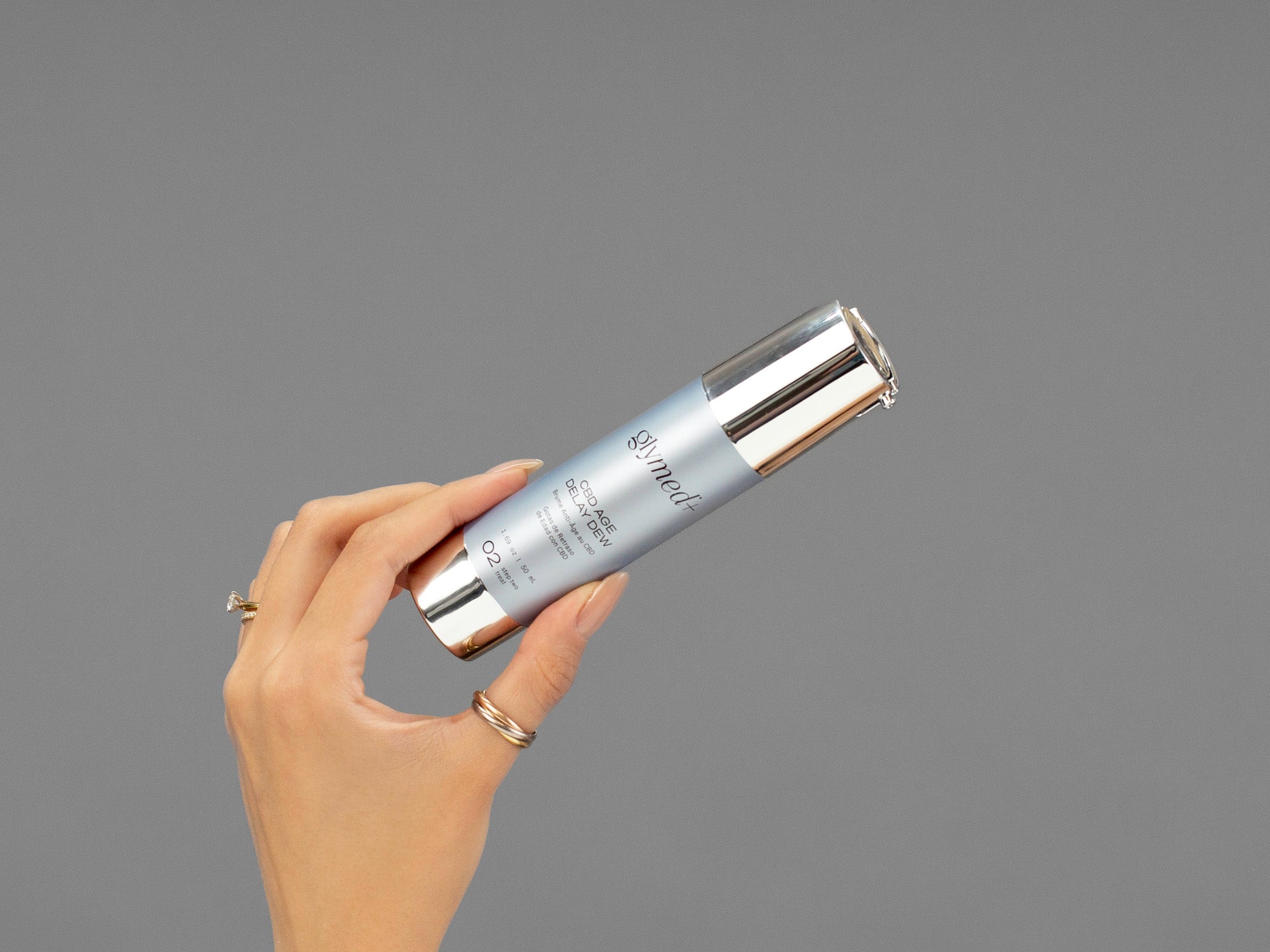 Closeup of Laziza from LAZ Skincare holding a bottle of GlyMed Hemp Age Delay Dew in her hand