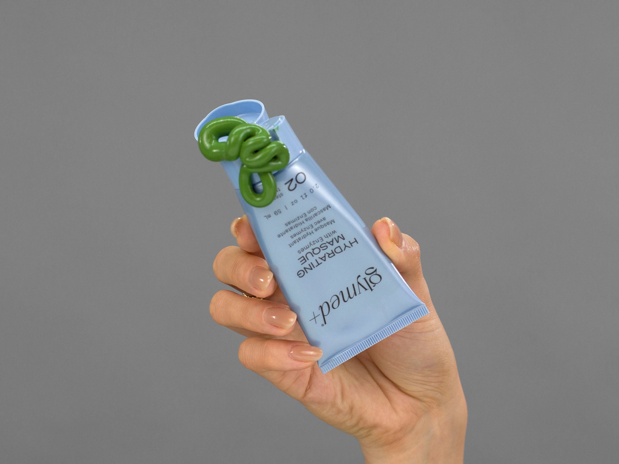 Closeup of Laziza from LAZ Skincare squeezing a tube of GlyMed Hydrating Masque in her hand