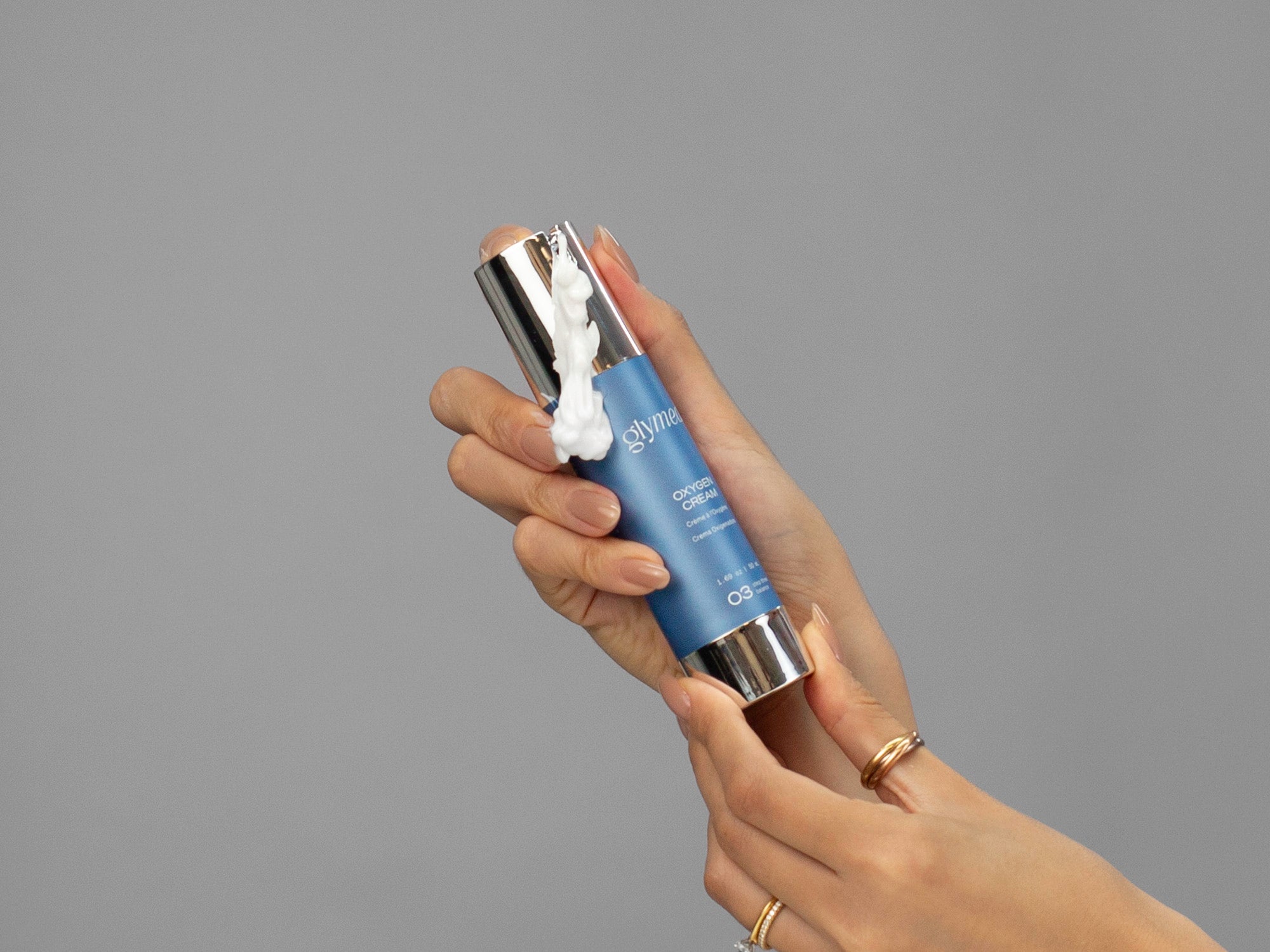 Closeup of Laziza from LAZ Skincare holding a bottle of GlyMed Oxygen Cream in her hand