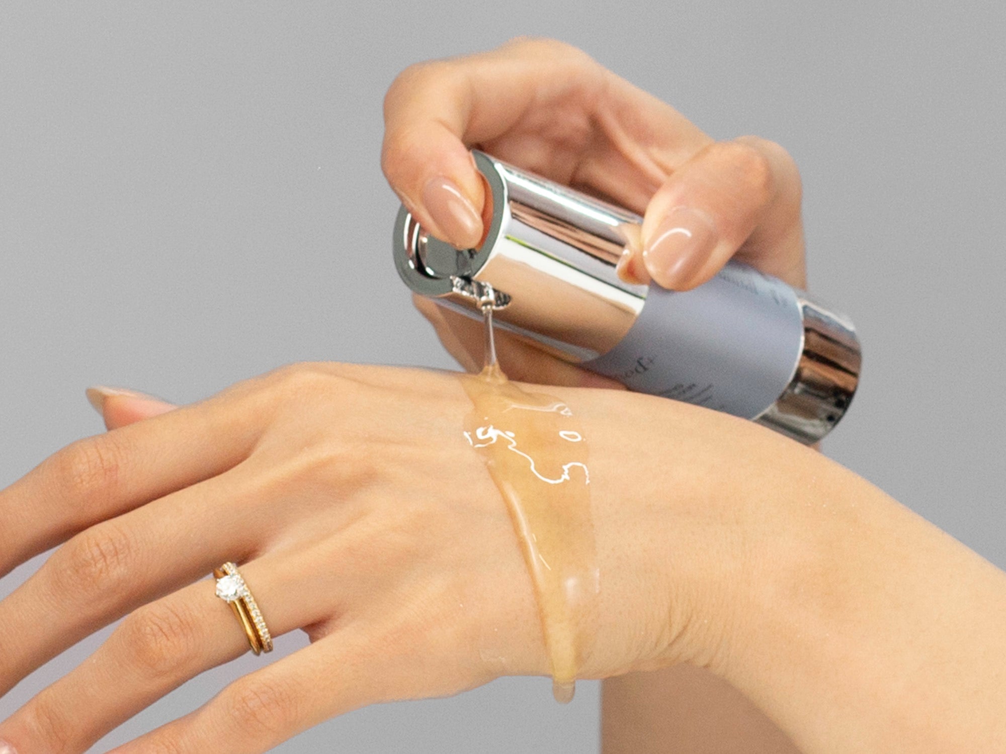 Closeup of Laziza from LAZ Skincare applying GlyMed Restoring Fulvic Elixir to her hand