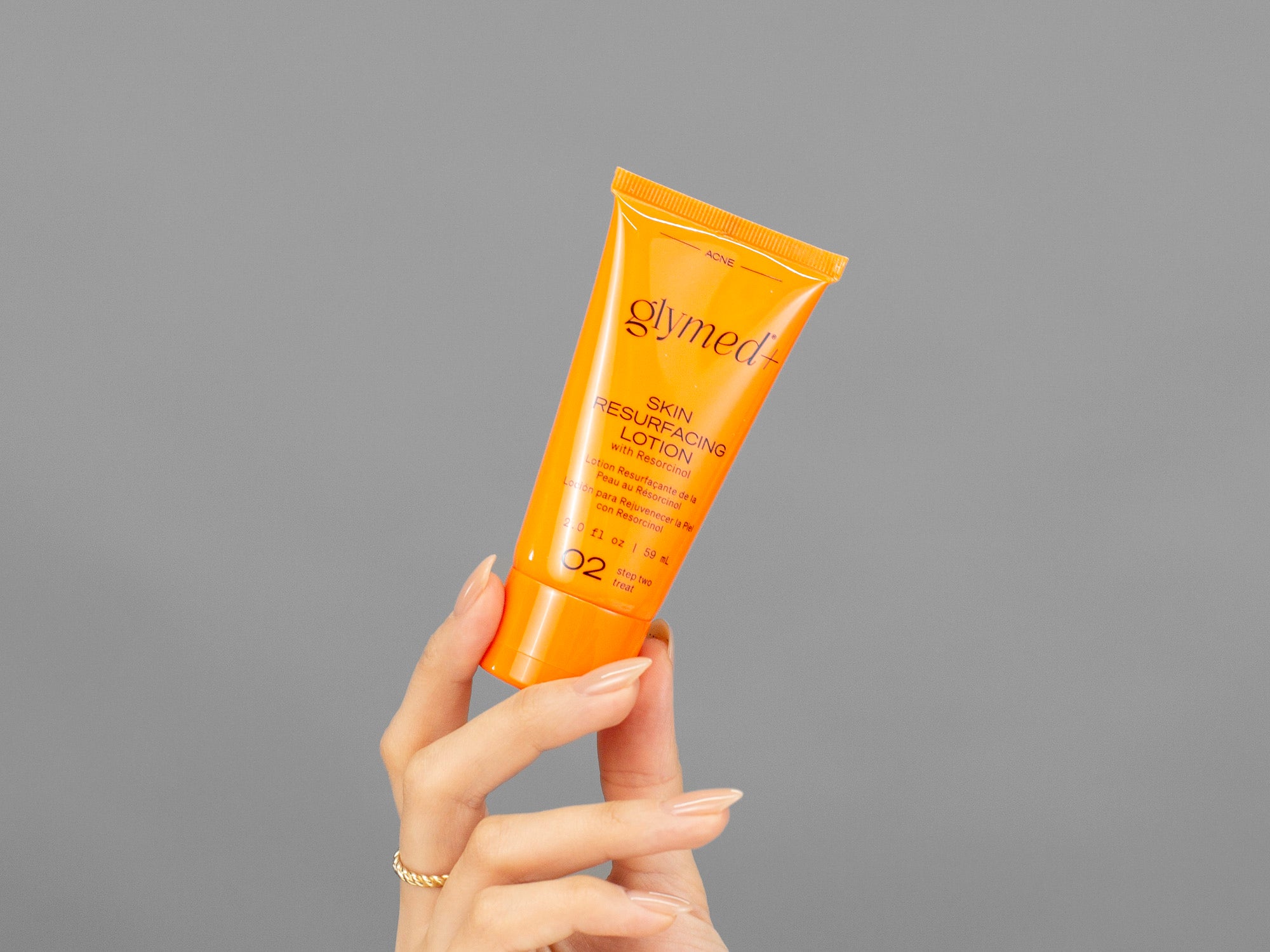 Closeup of Laziza from LAZ Skincare holding a tube of GlyMed Skin Resurfacing Lotion in her hand