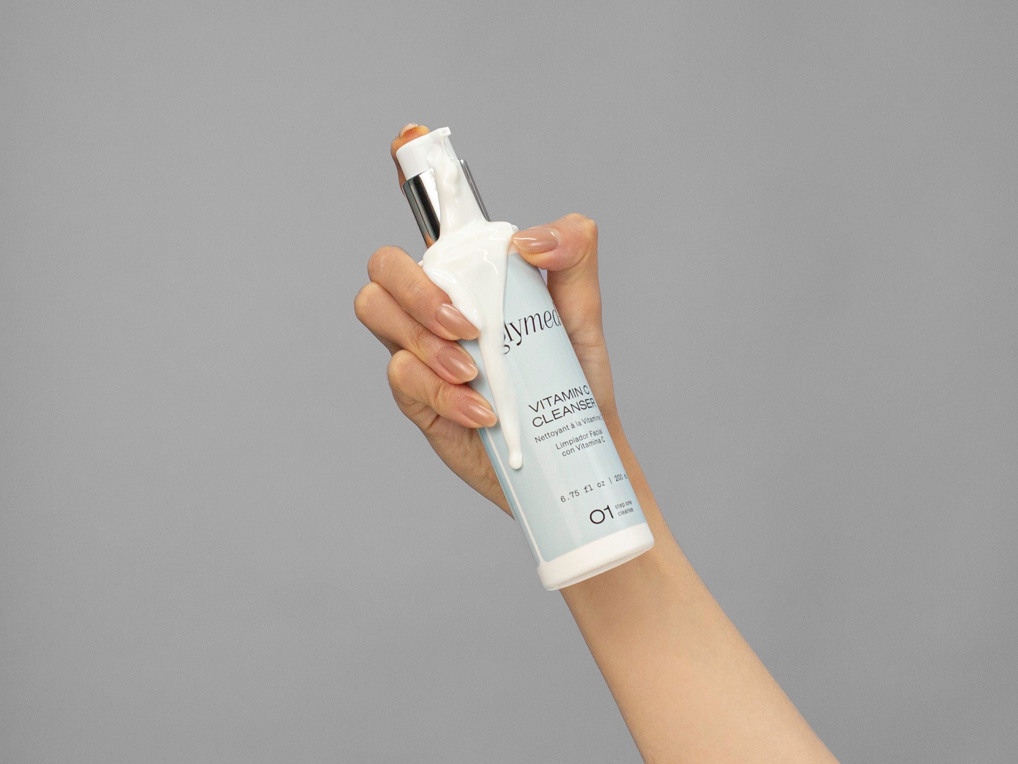 Closeup of Laziza from LAZ Skincare holding a bottle of GlyMed Vitamin C Cleanser in her hand