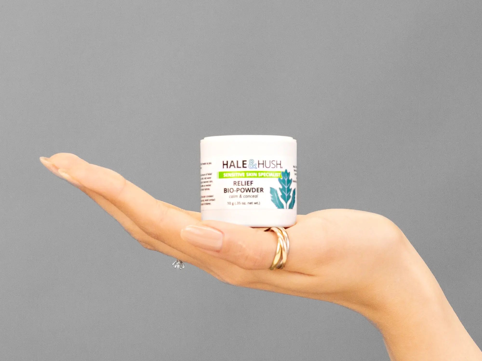 Closeup of Laziza from LAZ Skincare holding up a bottle of Hale & Hush Relief Bio-Powder