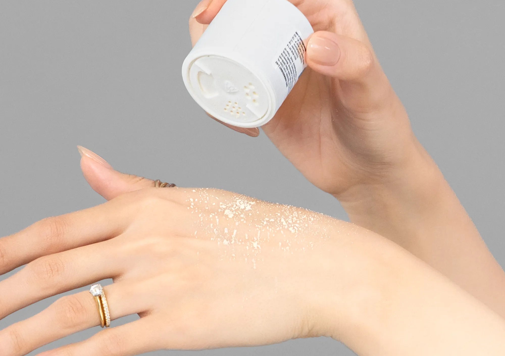 Laziza from LAZ Skincare demonstrating the texture and application of Hale & Hush Relief Bio-Powder on her hand