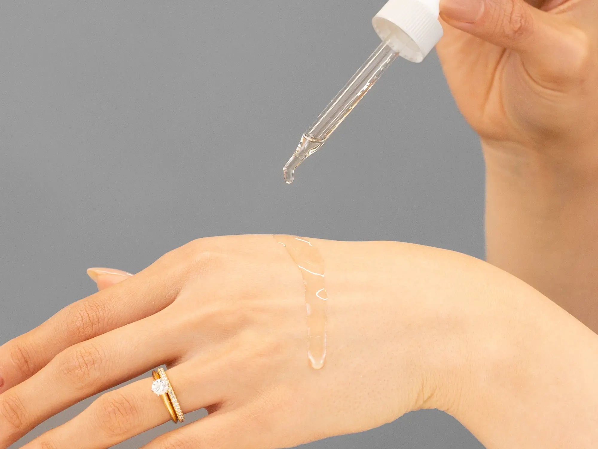 Laziza from LAZ Skincare demonstrating the texture and application of Hale & Hush Remedy Rehab Oil on her hand