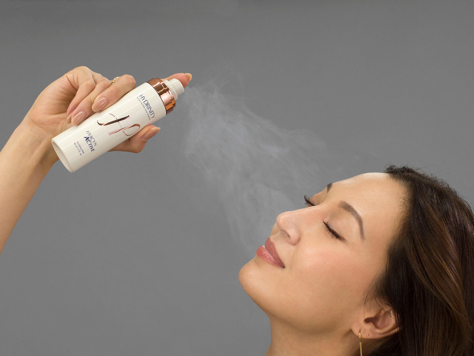 Laziza from LAZ Skincare spraying her face with Hydrinity Hyacyn Active Purifying Mist