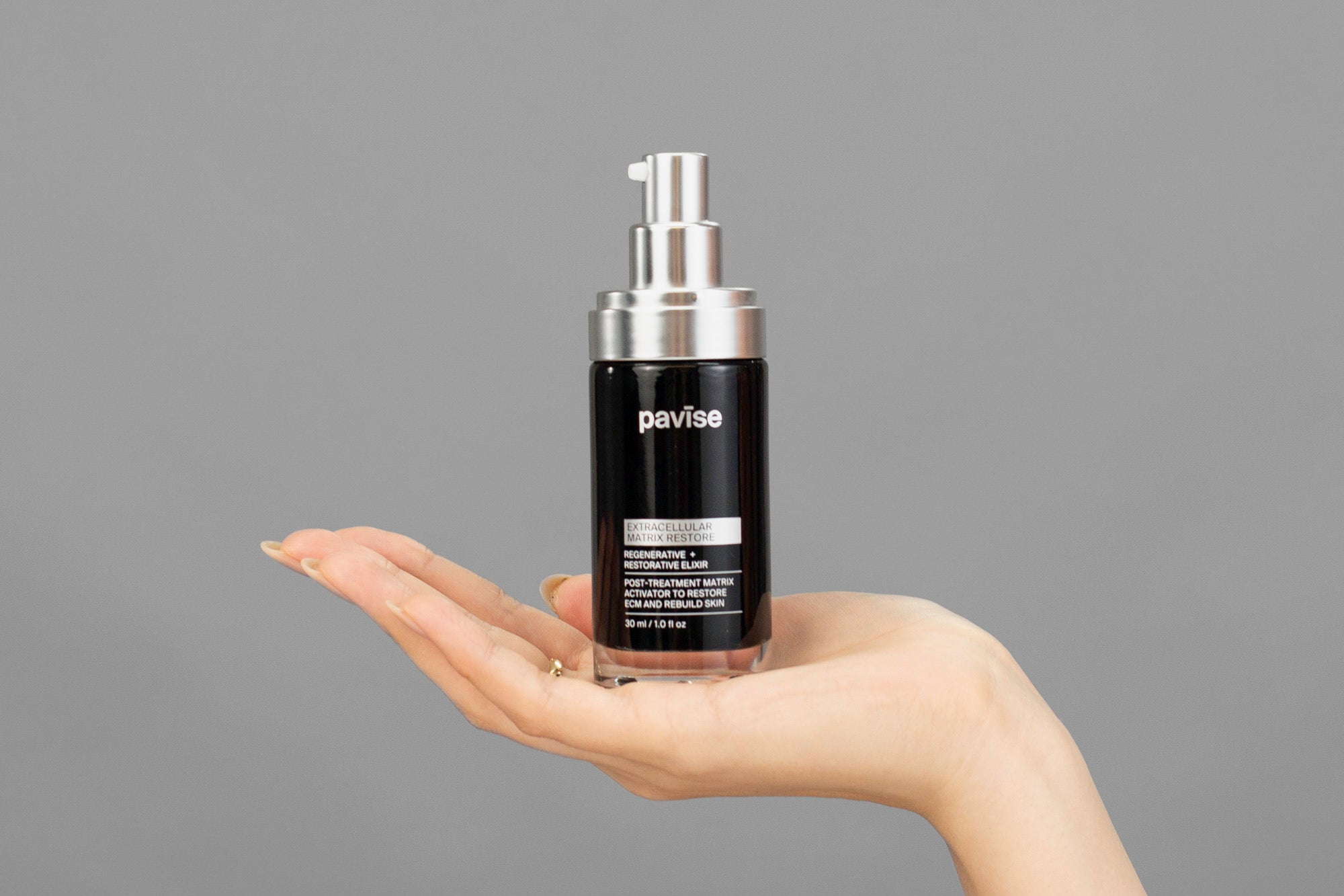 Closeup of Laziza from LAZ Skincare holding up a bottle of Pavise Extracellular Matrix Restore