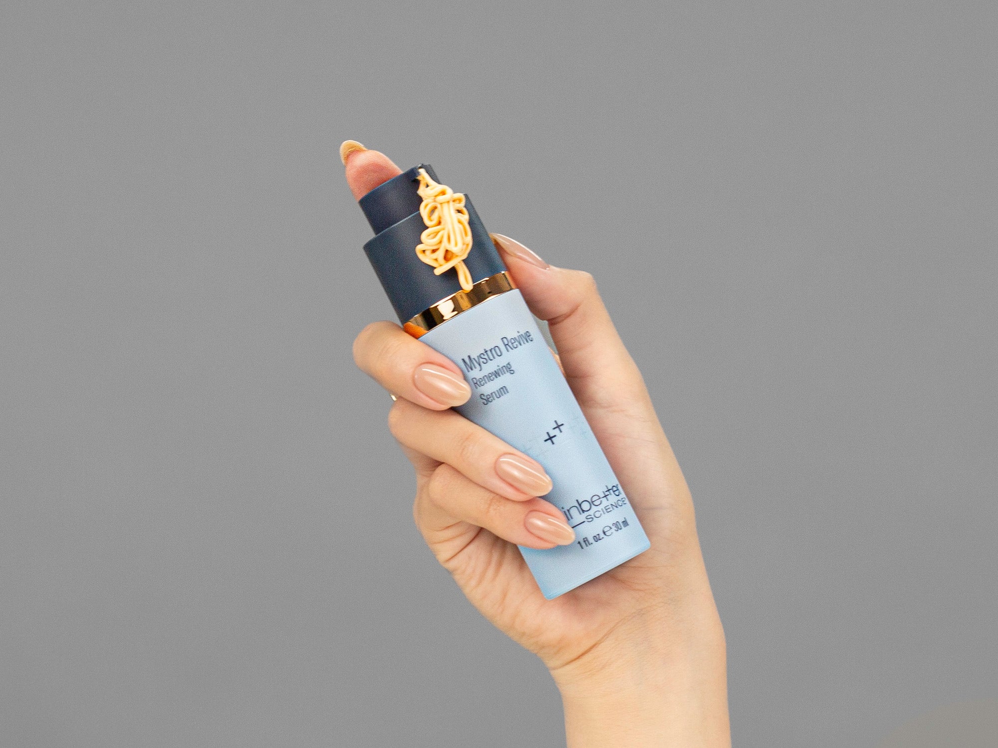 Closeup of Laziza from LAZ Skincare holding a bottle of Skinbetter Science Mystro Revive Renewing Serum