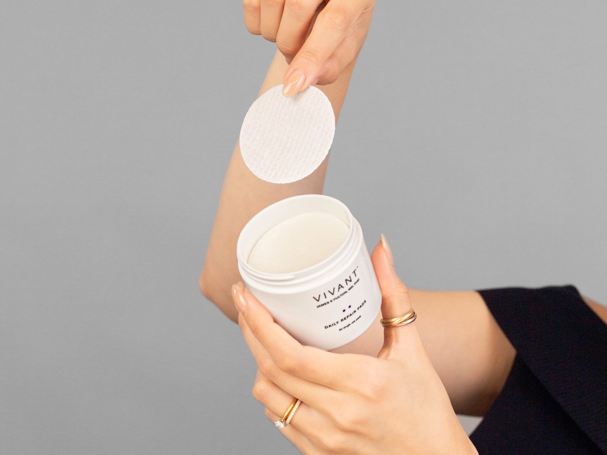 Closeup of Laziza from LAZ Skincare taking a Vivant Daily Repair Pad from its container