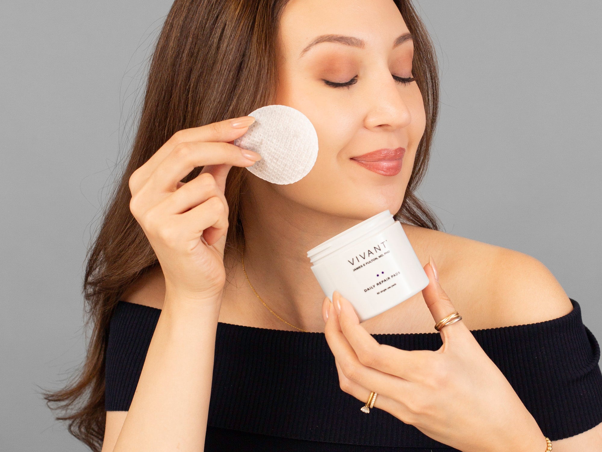 Laziza from LAZ Skincare applying a Vivant Daily Repair Pad to her face