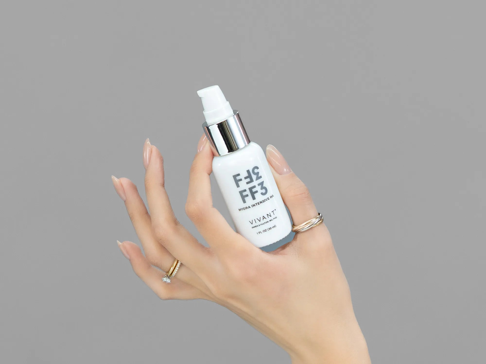 Closeup of Laziza from LAZ Skincare holding up a bottle of Vivant FF3 Hydra Intensive HA