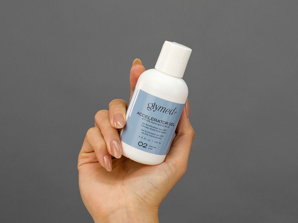 Closeup of Laziza from LAZ Skincare holding up a bottle of GlyMed Accelerator Gel