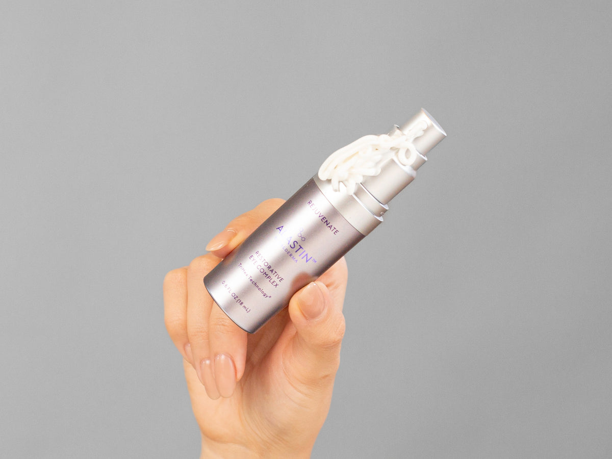 Closeup of Laziza from LAZ Skincare holding up a bottle of Alastin Restorative Eye Complex