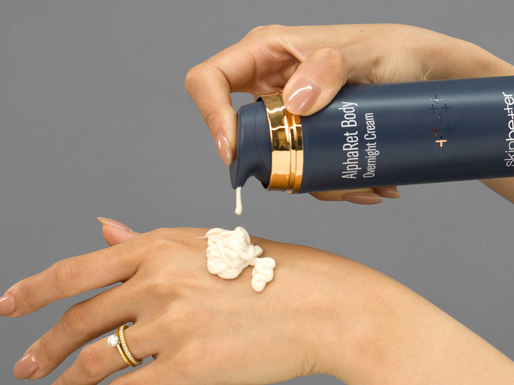 Closeup of Laziza from LAZ Skincare holding up a bottle of SkinBetter Science AlphaRet Body Overnight Cream