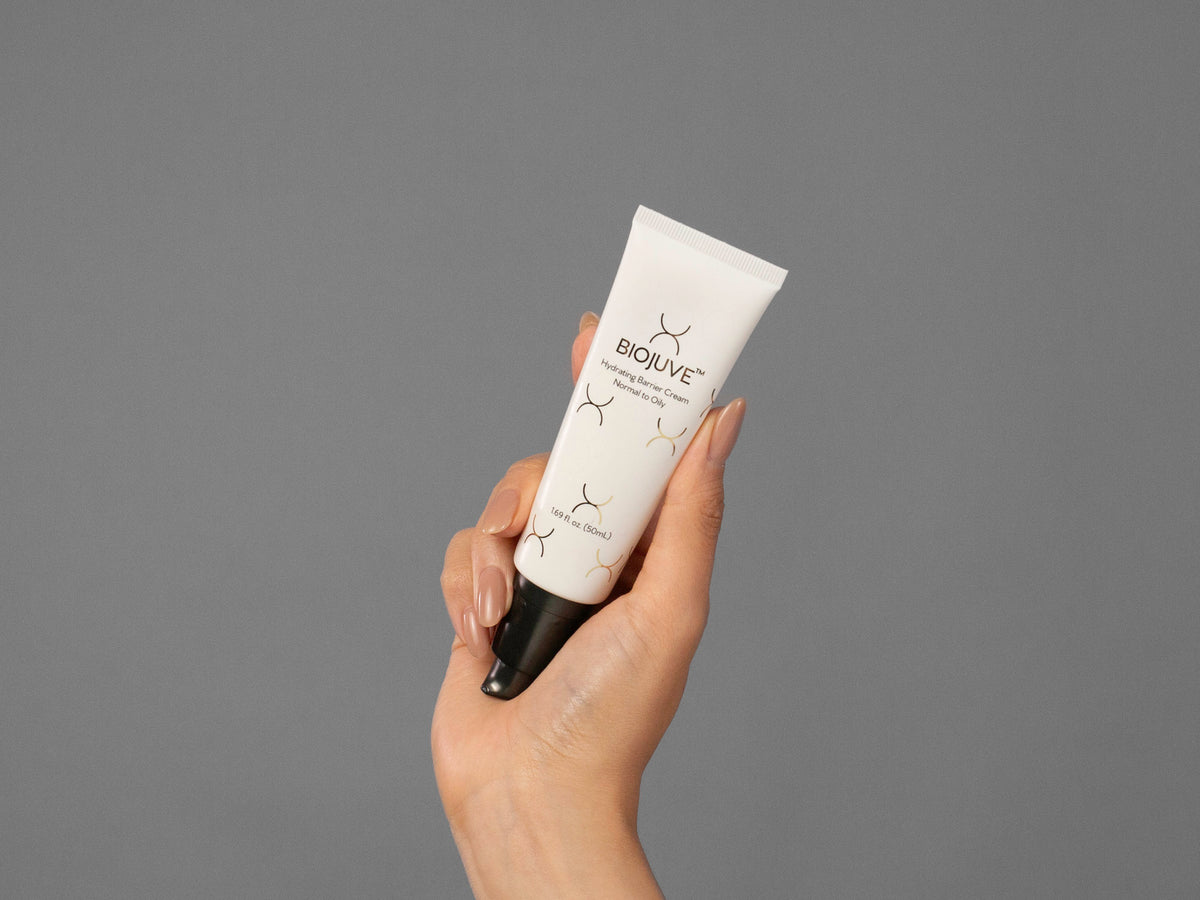 Closeup of Laziza from LAZ Skincare holding up a bottle of Biojuve Hydrating Barrier Cream
