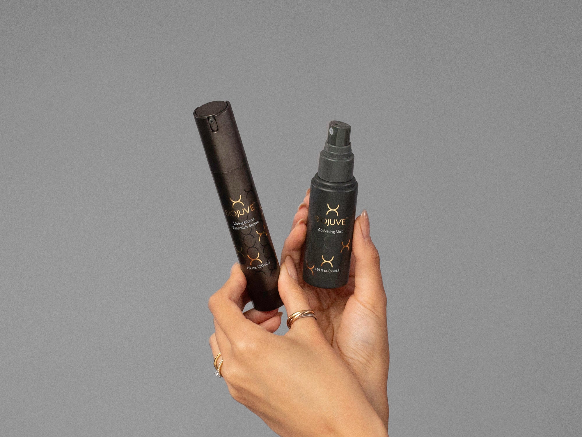 Closeup of Laziza from LAZ Skincare holding bottles of BioJuve Living Biome Essentials Serum and Mist in her hands