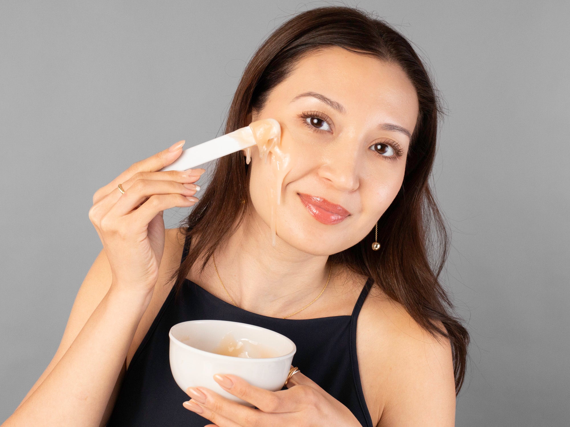 Laziza from LAZ Skincare demonstrating how to apply the CO2Lift Pro Carboxy Gel Mask with the included spatula