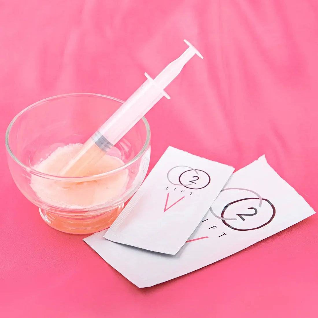 Laziza from LAZ Skincare holding a bottle of Lumisque CO2Lift V Vaginal Treatment up to her face