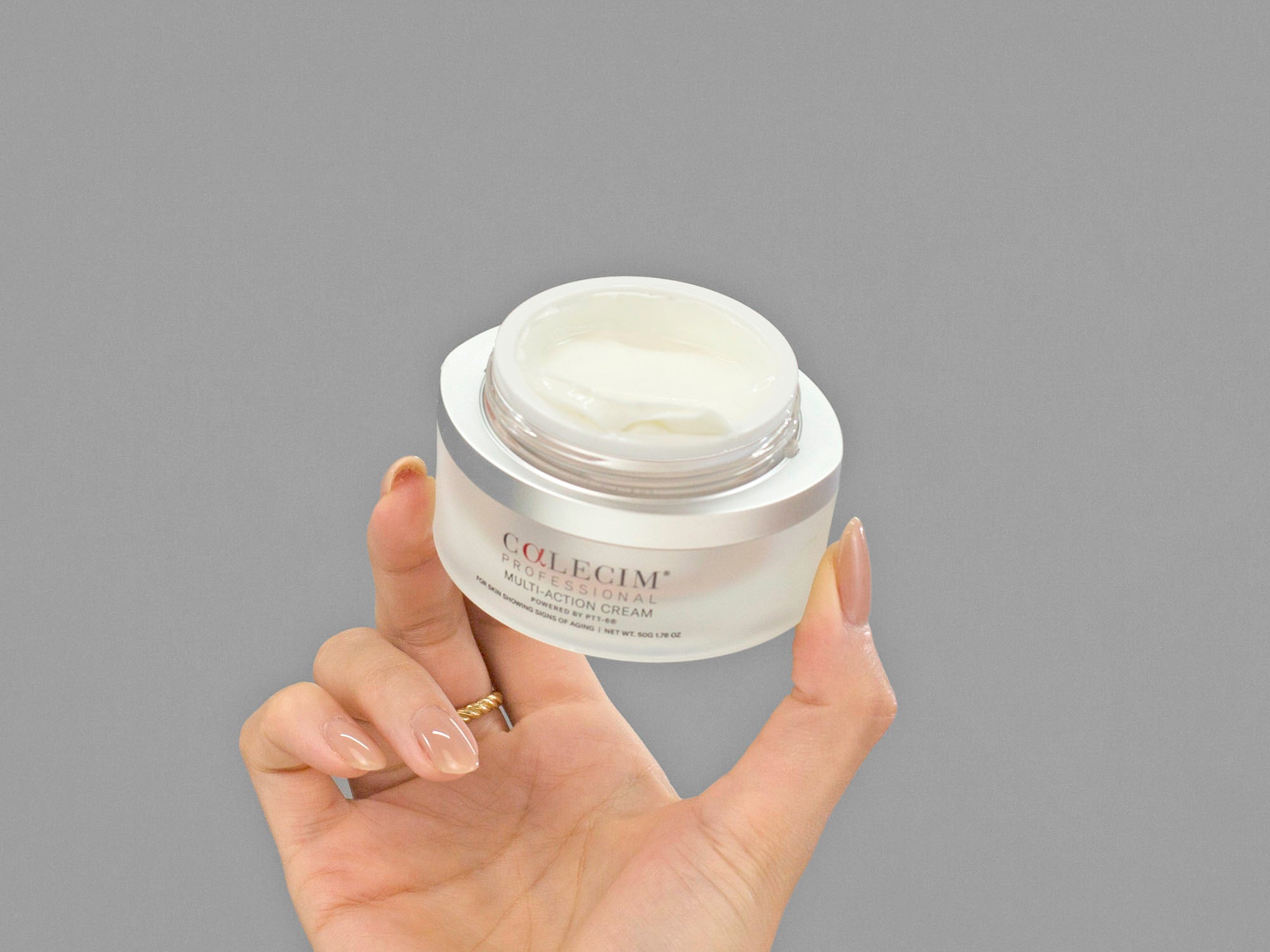 Closeup of Laziza from LAZ Skincare holding an open jar of Calecim Multi-Action Cream in her hand