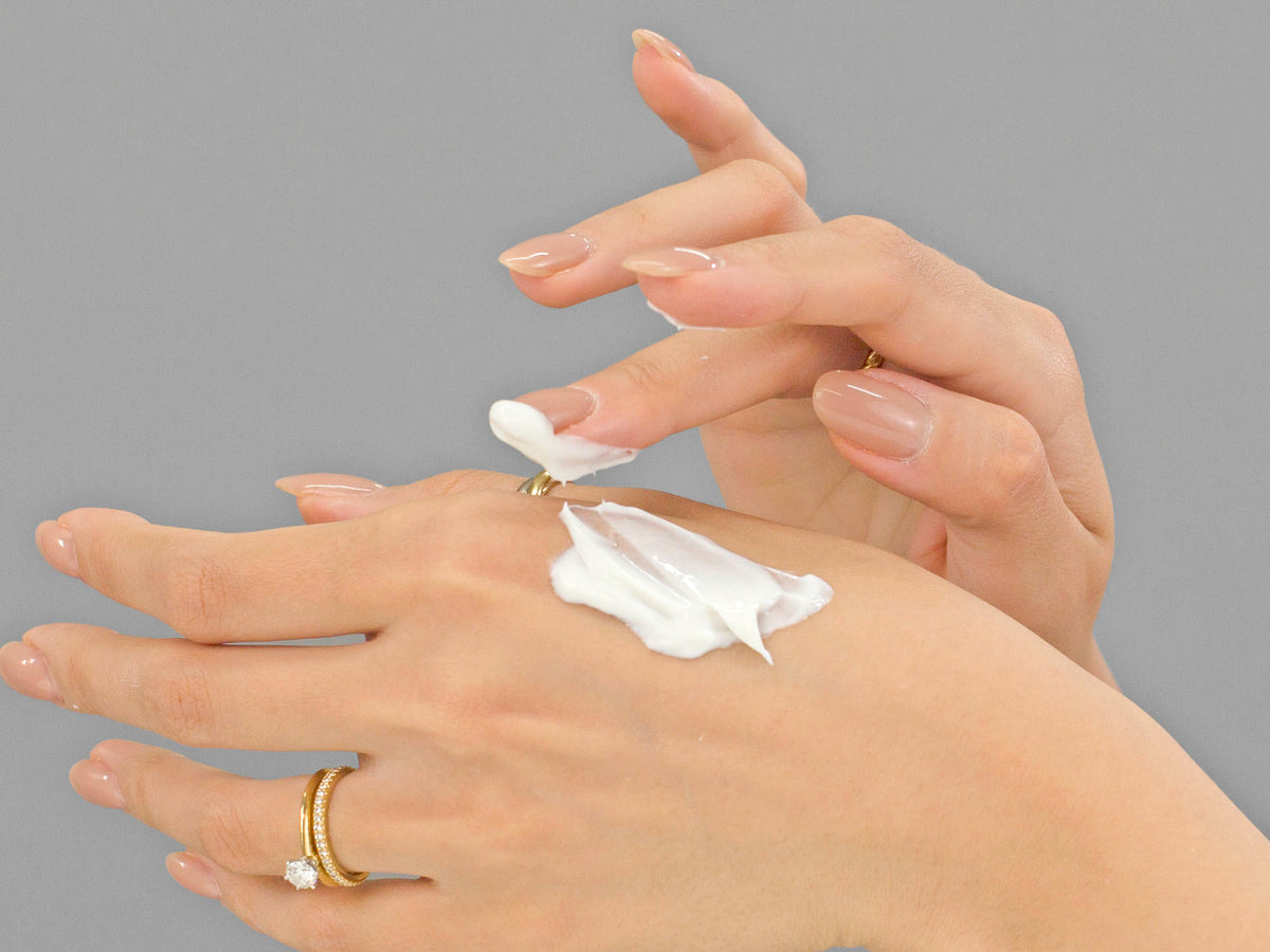 Laziza from LAZ Skincare demonstrating the texture and application of Calecim Multi-Action Cream on her hand