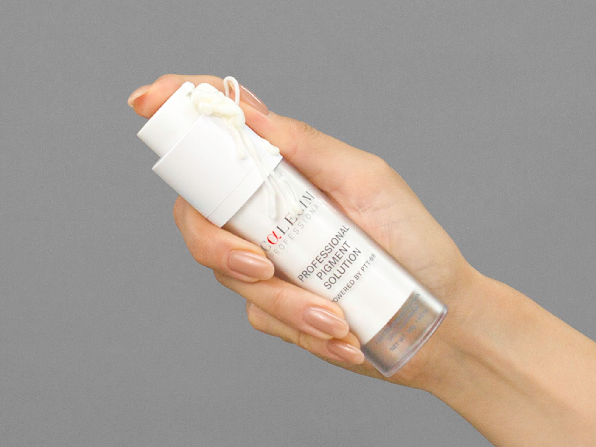 Closeup of Laziza from LAZ Skincare holding a bottle of Calecim Professional Pigment Solution in her hand