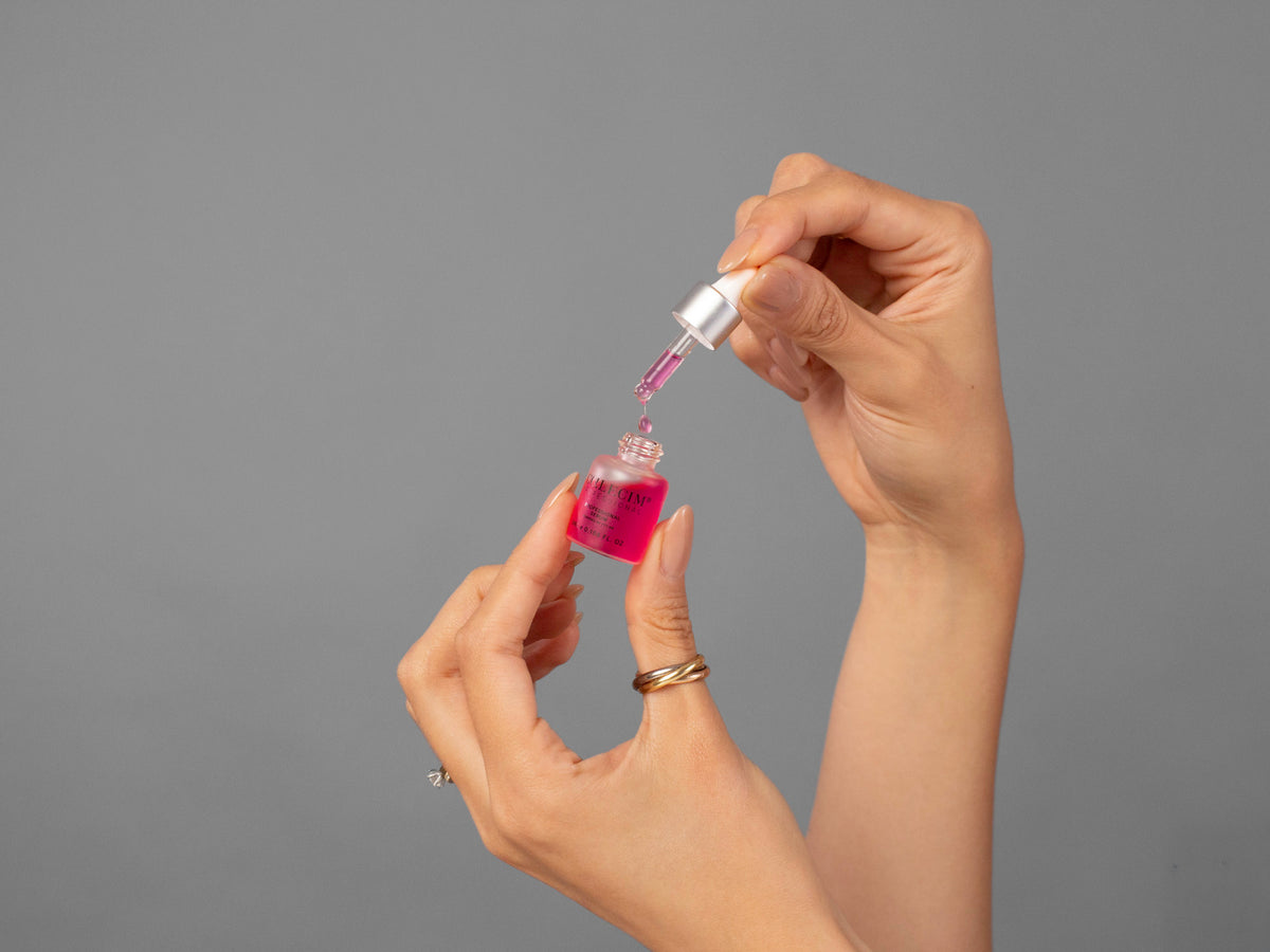Closeup of Laziza from LAZ Skincare holding up a bottle of Calecim Professional Serum