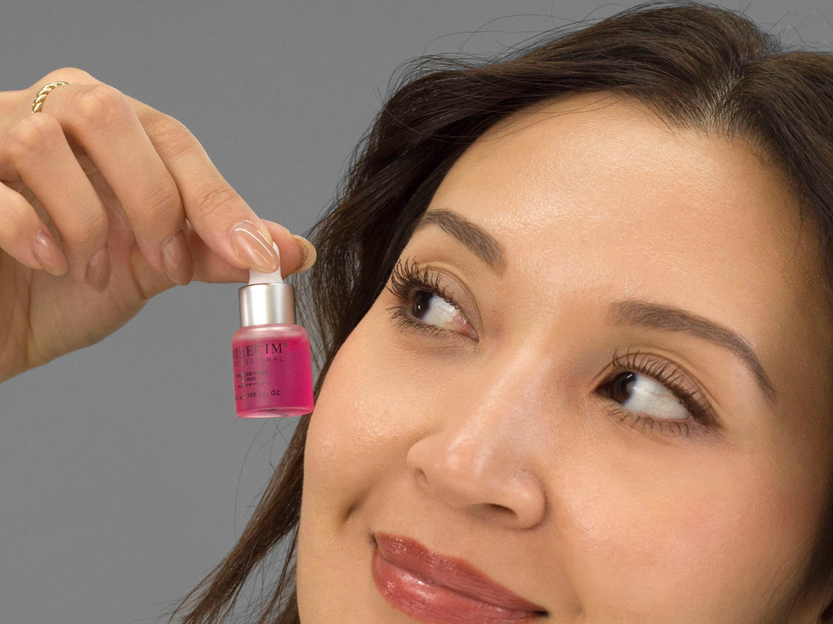 Laziza from LAZ Skincare holding a bottle of Calecim Professional Serum up to her face
