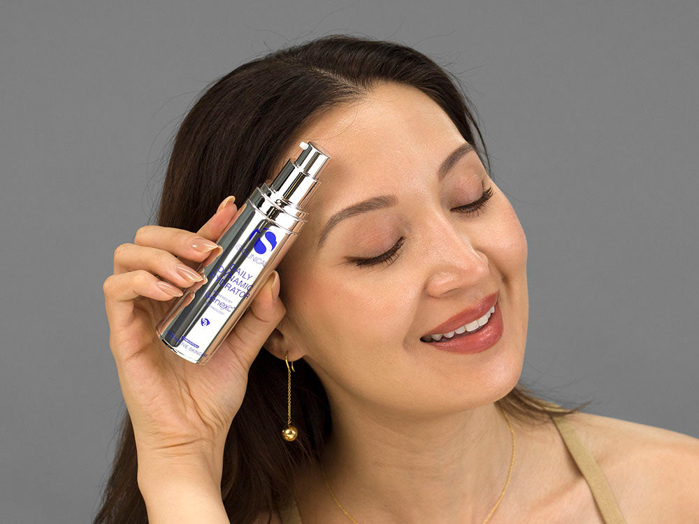 Laziza from LAZ Skincare holding a bottle of iS Clinical Daily Dynamic Hydrator up to her face