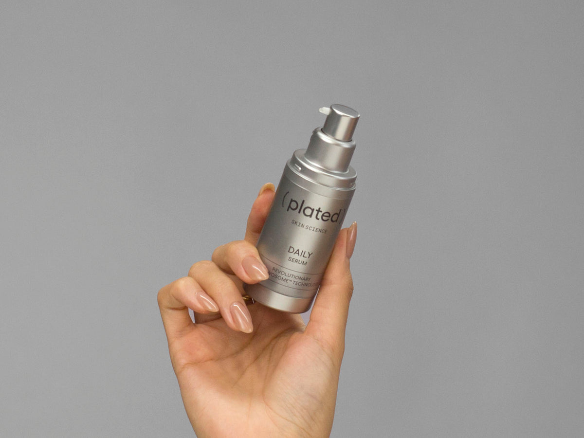 Closeup of Laziza from LAZ Skincare holding up a bottle of Plated Daily Serum