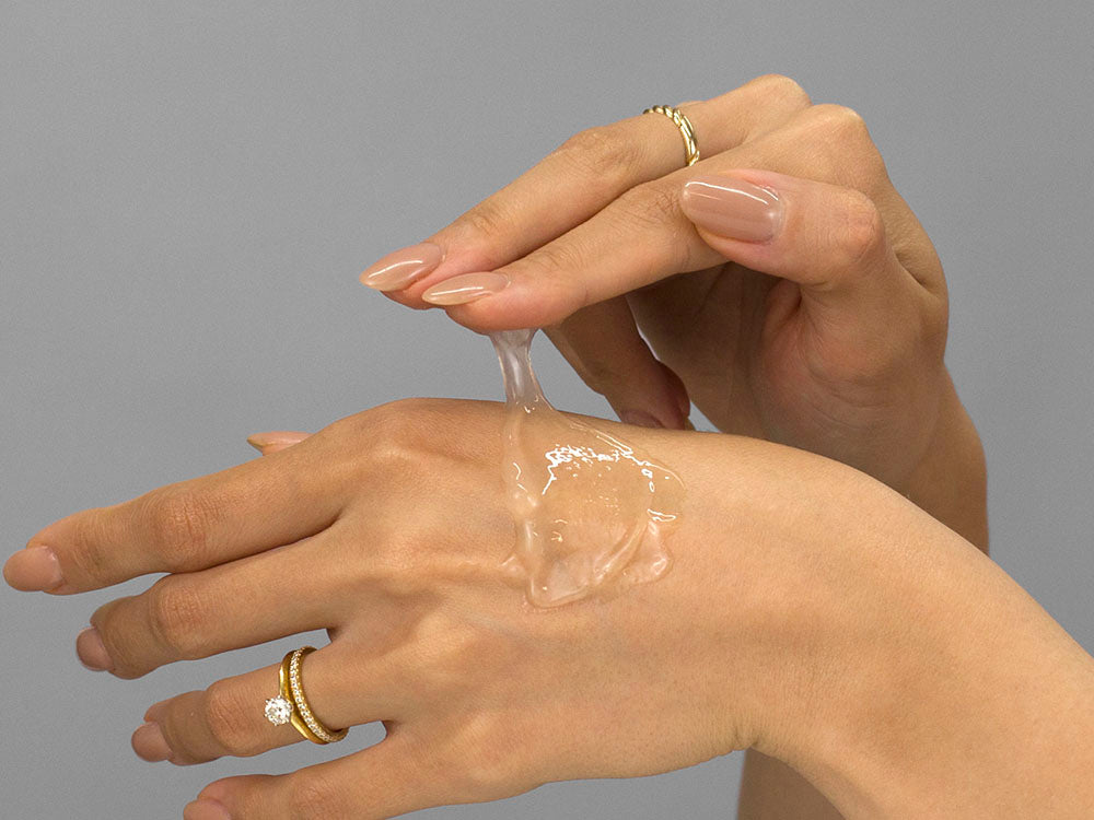 Laziza from LAZ Skincare demonstrating the texture and application of Plated Daily Serum on her hand