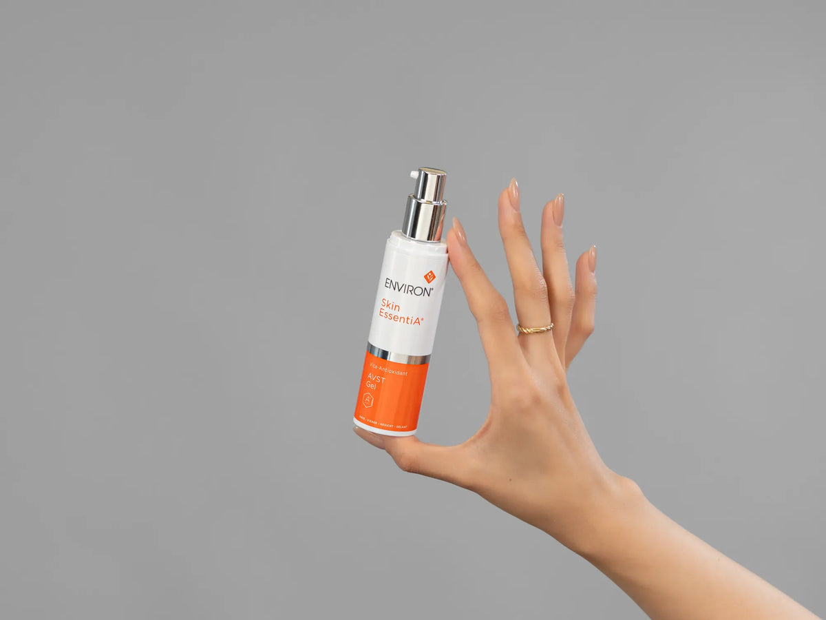 Closeup of Laziza from LAZ Skincare holding up a bottle of Environ AVST Gel