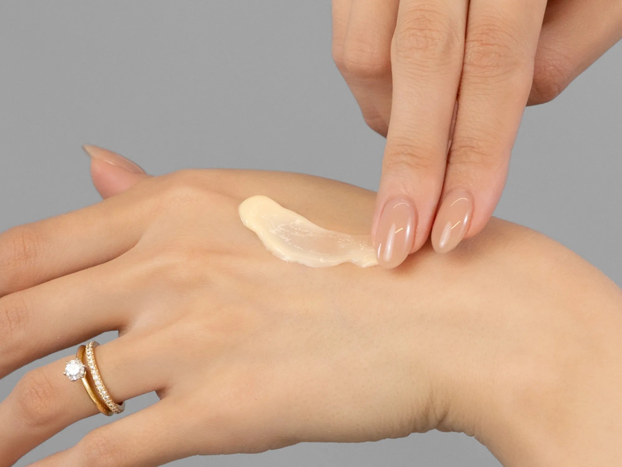 Laziza from LAZ Skincare demonstrating the texture and application of Environ AVST Moisturiser on her hand