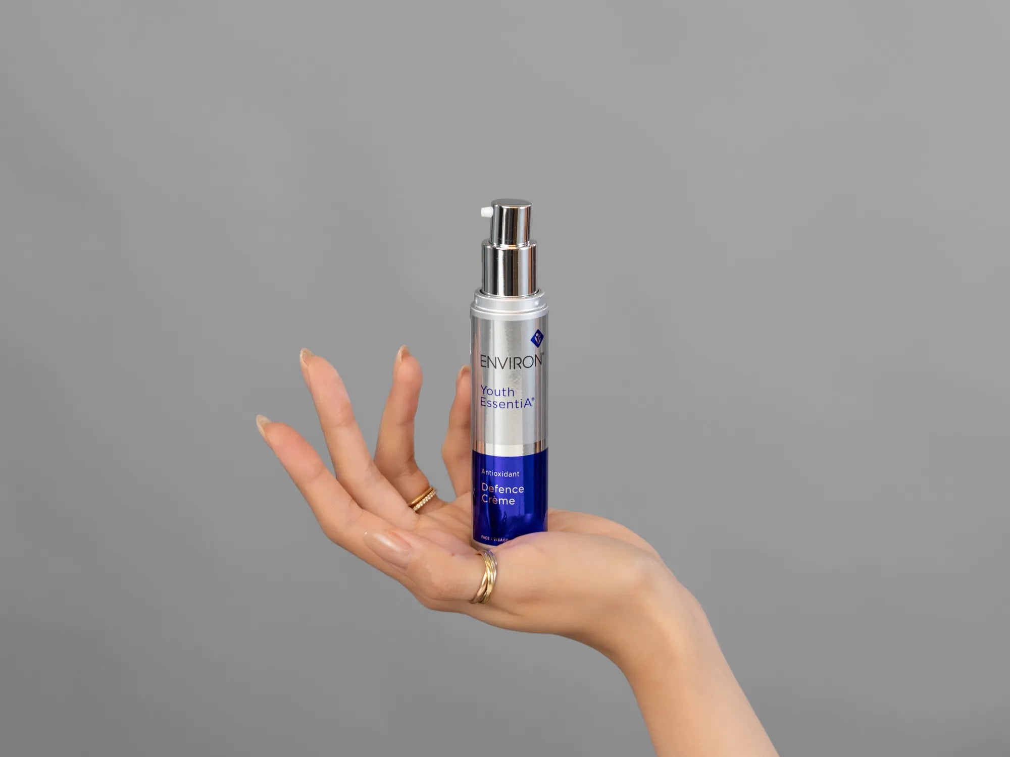 Closeup of Laziza from LAZ Skincare holding up a bottle of Environ Defence Creme